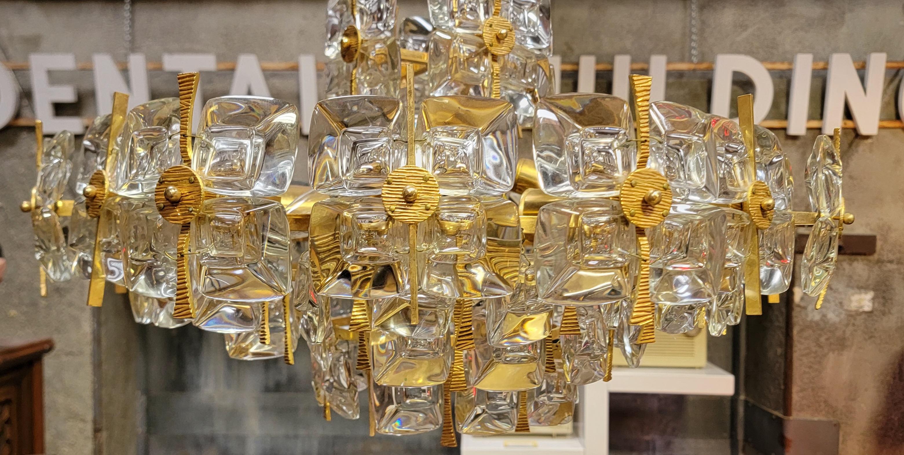 Magnifique lustre de style Mid-Century Modern / Hollywood Regency wedding cake design par Gaetano Sciolari pour Palwa, Allemagne circa. 1970's Laiton doré et cristal avec maillon de chaîne décoré d'origine et plaque d'écusson en cristal. Le lustre