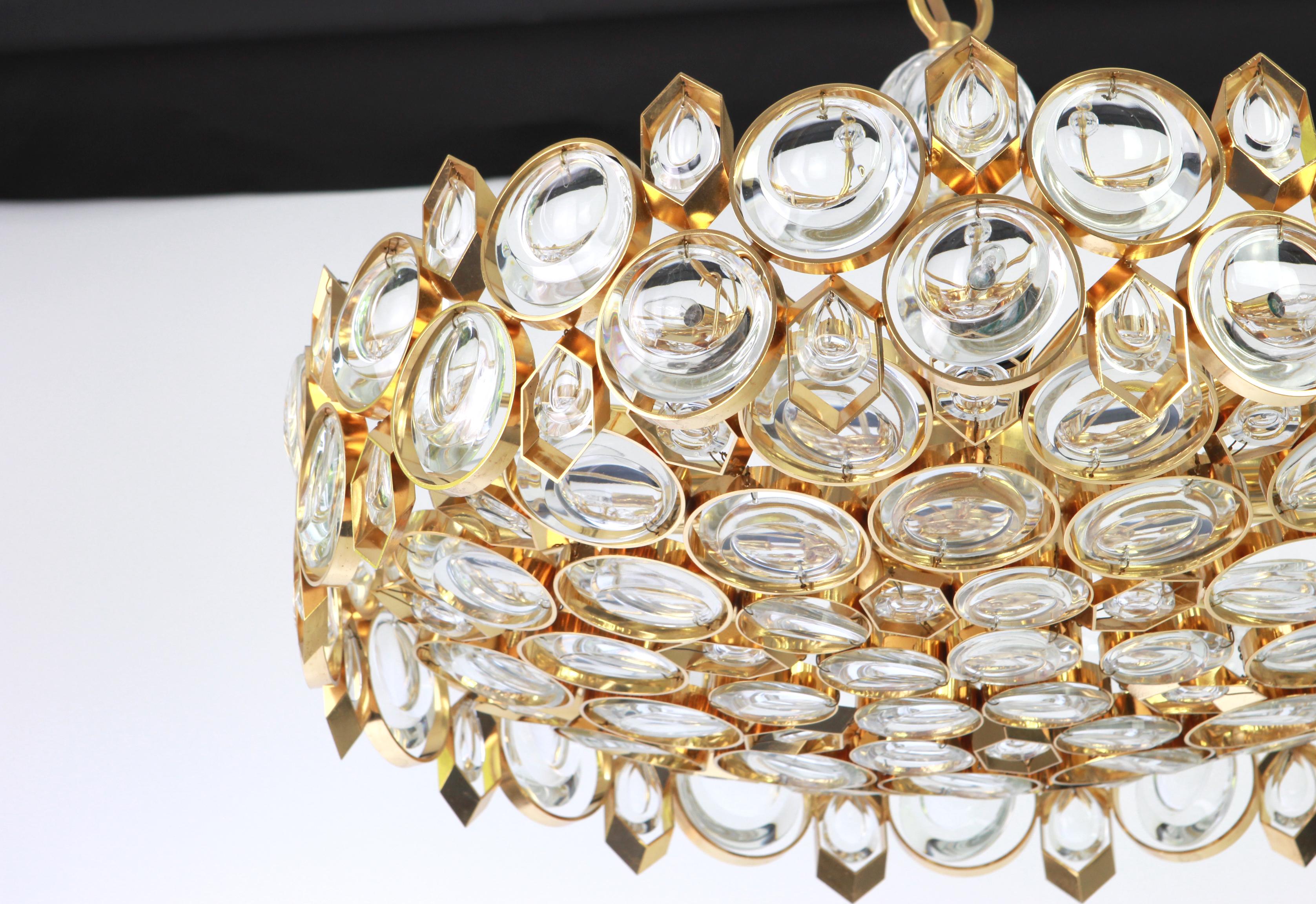 A wonderful and high quality gilded chandelier or pendant light fixture by Palwa -Design Sciolari, Germany, 1970s.
It is made of a 24 carat gold-plated brass frame decorated with individual 