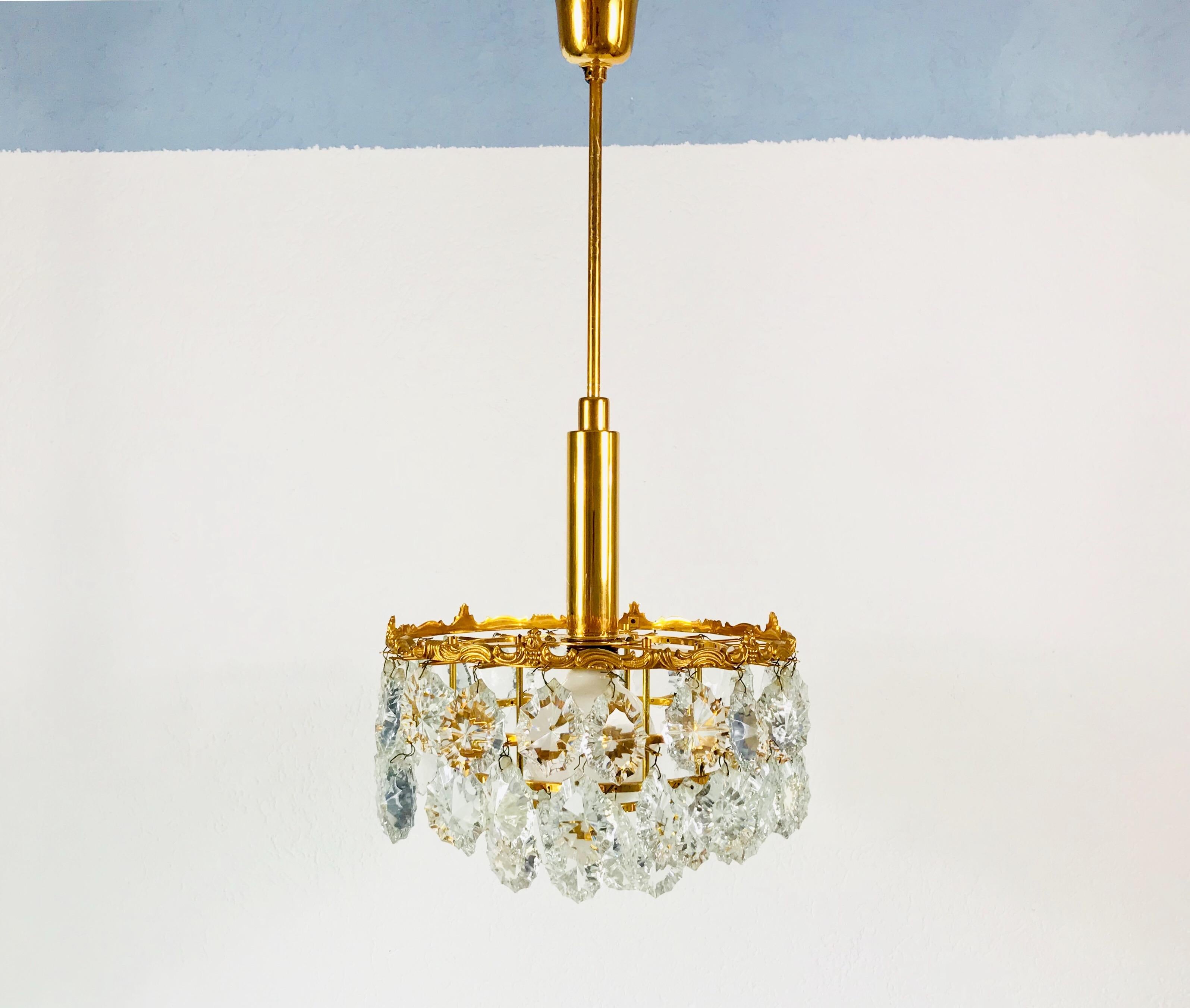 Hollywood Regency Gilt Brass and Crystal Glass 4-Tier Chandelier by Palwa, Germany, 1970s For Sale