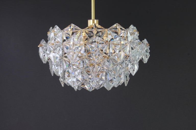 A stunning five-tier chandelier by Kinkeldey, Germany, manufactured in circa 1970-1979. A handmade and high quality piece. The chandelier features a 24-karat gold-plated four-tier structure with lots of facetted crystal glass elements.

High