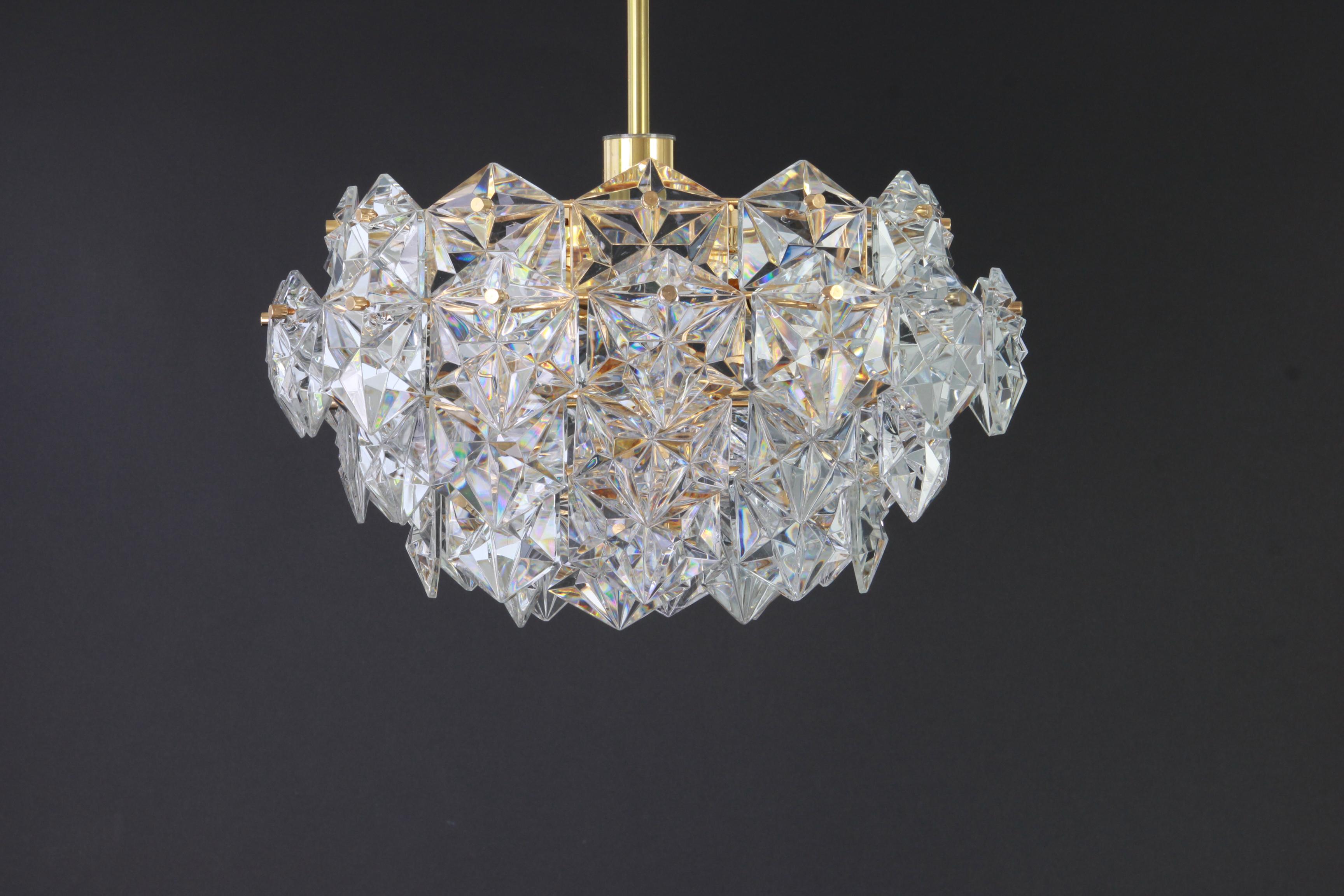 A stunning five-tier chandelier by Kinkeldey, Germany, manufactured in circa 1970-1979. A handmade and high quality piece. The chandelier features a 24-karat gold-plated four-tier structure with lots of facetted crystal glass elements.

High