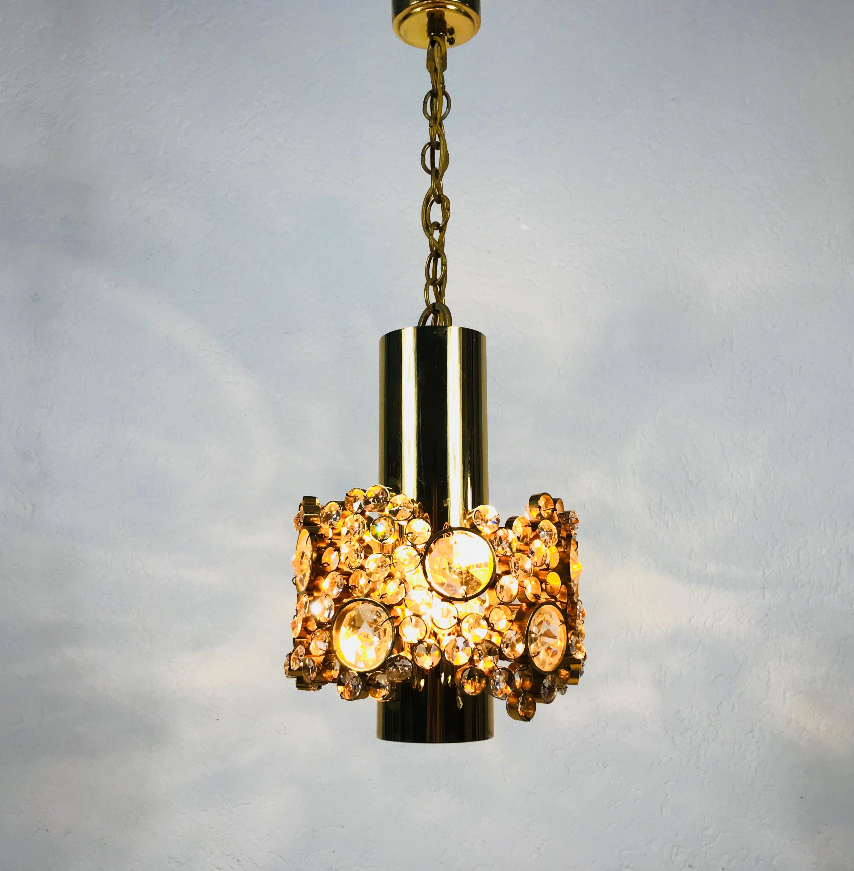 An extraordinarry pendant lamp by Palwa made in Germany in the 1970s. The lamp has a very elegant design. It is made in the period of Hollywood Regency. Round Gilt brass body with one E27 socket. The socket is surrounded with very elegant crystals.