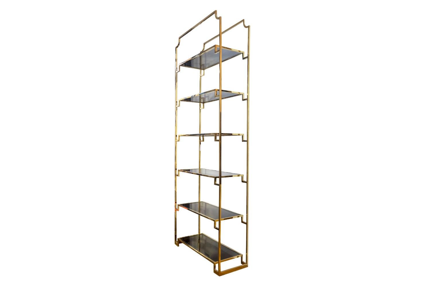 Gilt brass shelf composed of six smoked glass tray. Structure made of gilt brass in square section, upper crossbar with rounded canted corners.

Contemporary work.