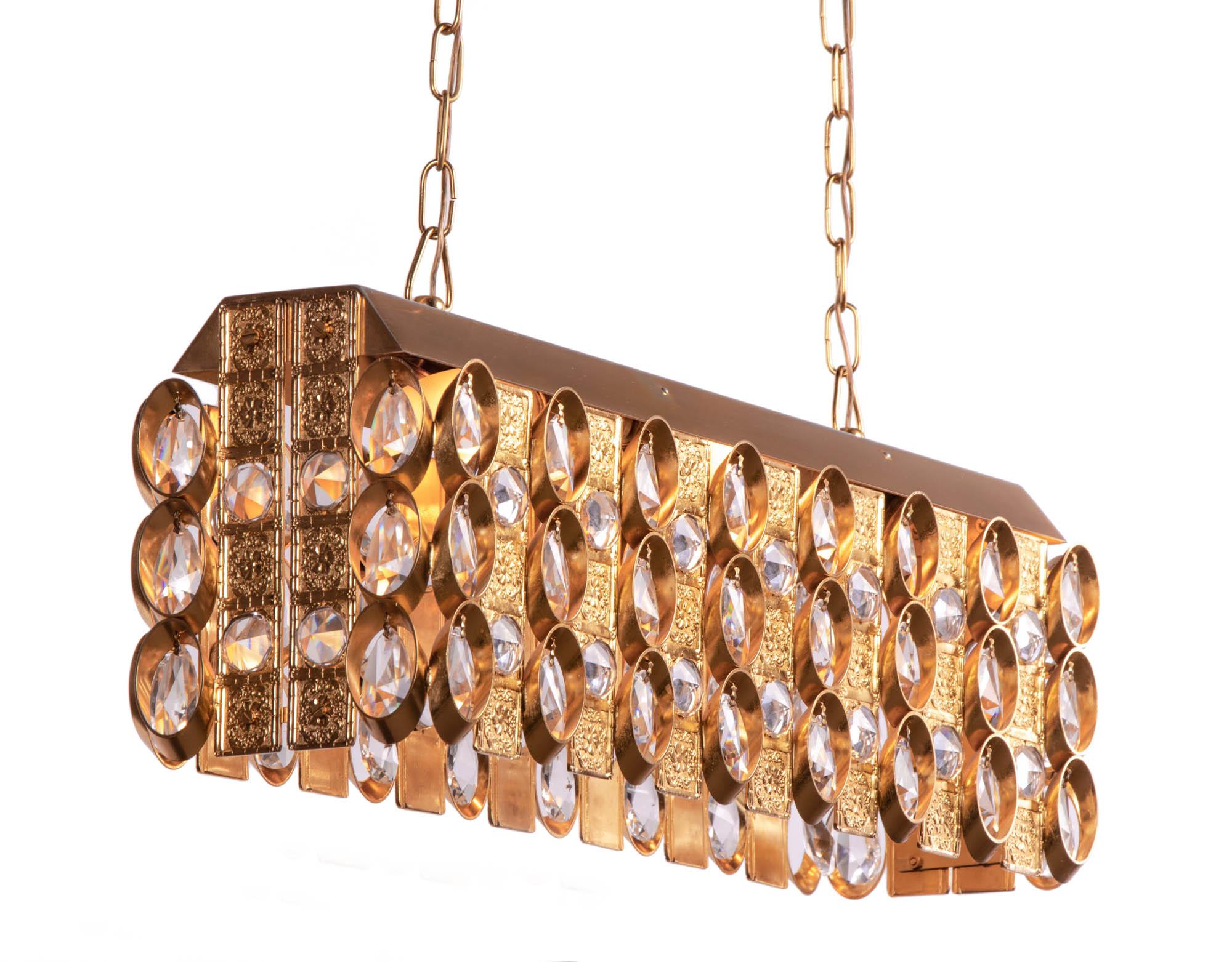 Glamorous crystal chandelier made of a gold-plated brass frame with crystal prisms designed by Christoph Palme. Chandelier illuminates beautifully and offers a lot of light. Gem from the time. With this light you make a clear statement in your