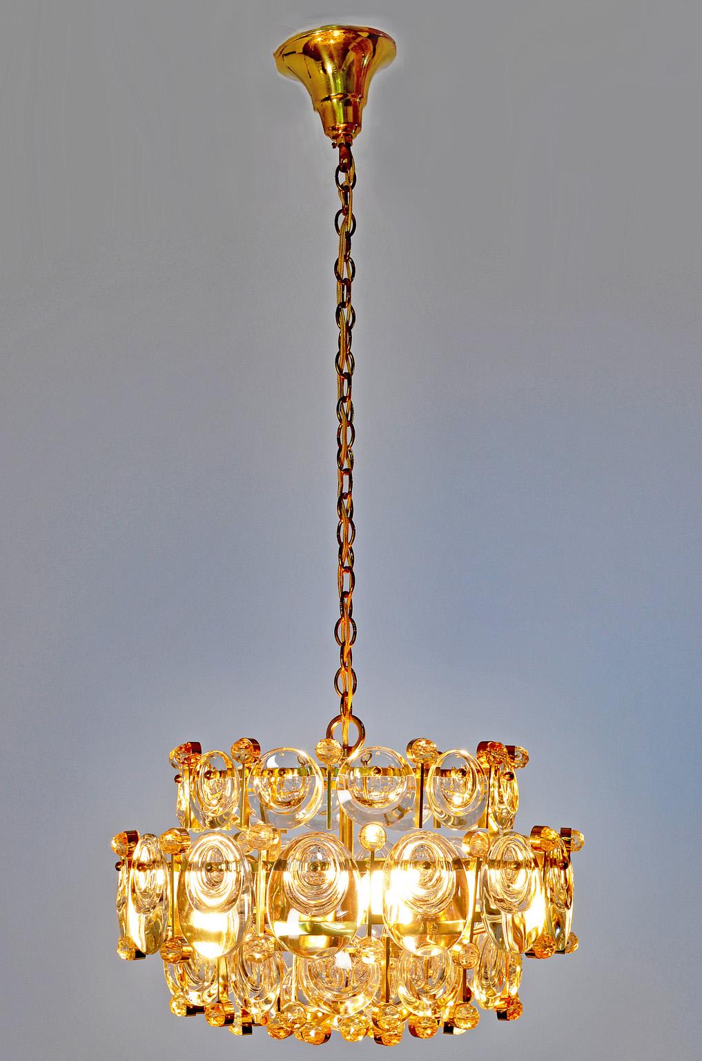 This chandelier is made of gilded brass and crystal glass.
It is labeled by Palwa, who produced the lamp in the 1960s.
