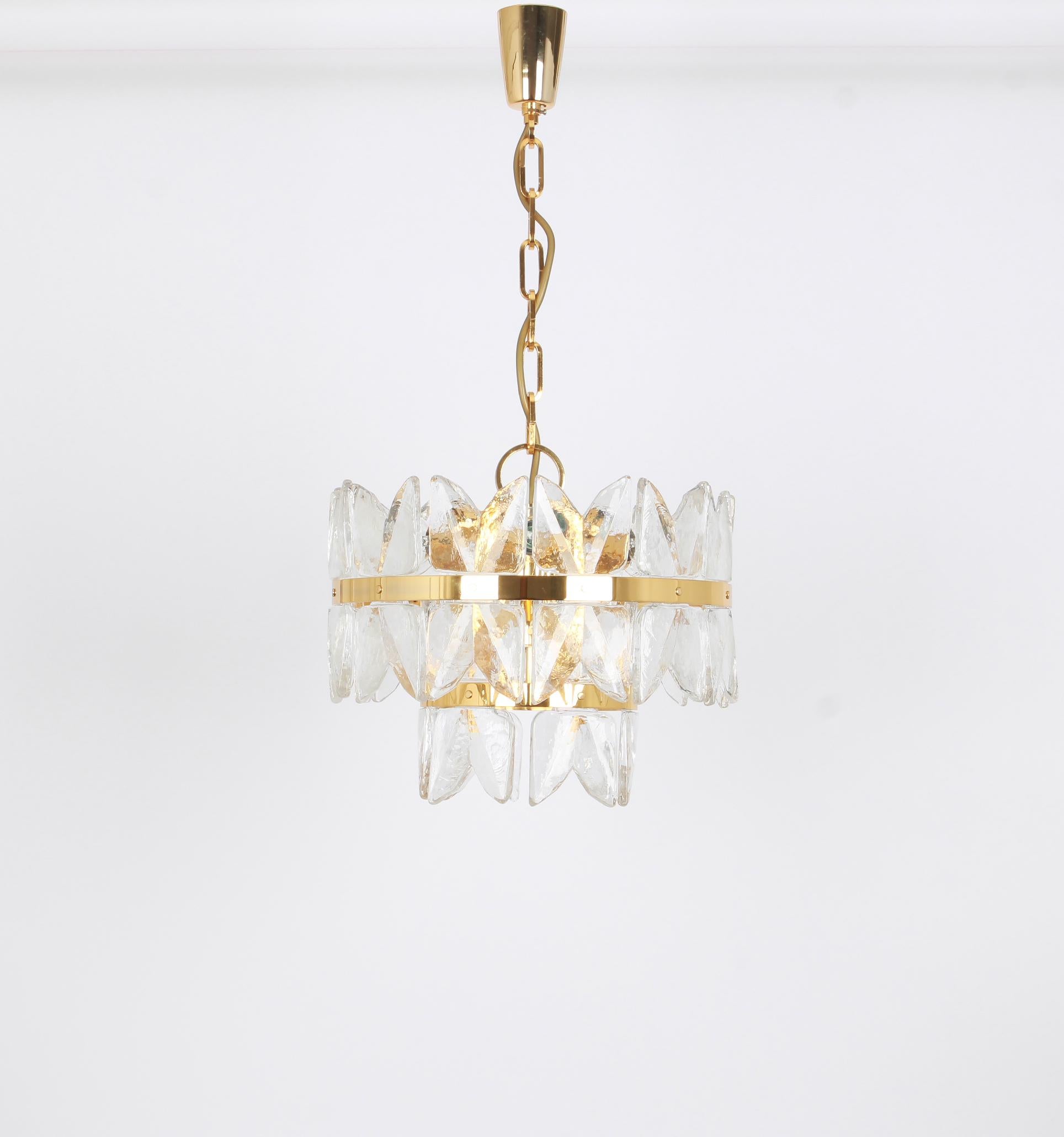 A wonderful gilt brass light fixture made by Kalmar (Series: Corina), Austria, manufactured, circa 1970-1979.
Three tiers structure gathering many structured polished crystal glass pieces, beautifully refracting the light very heavy