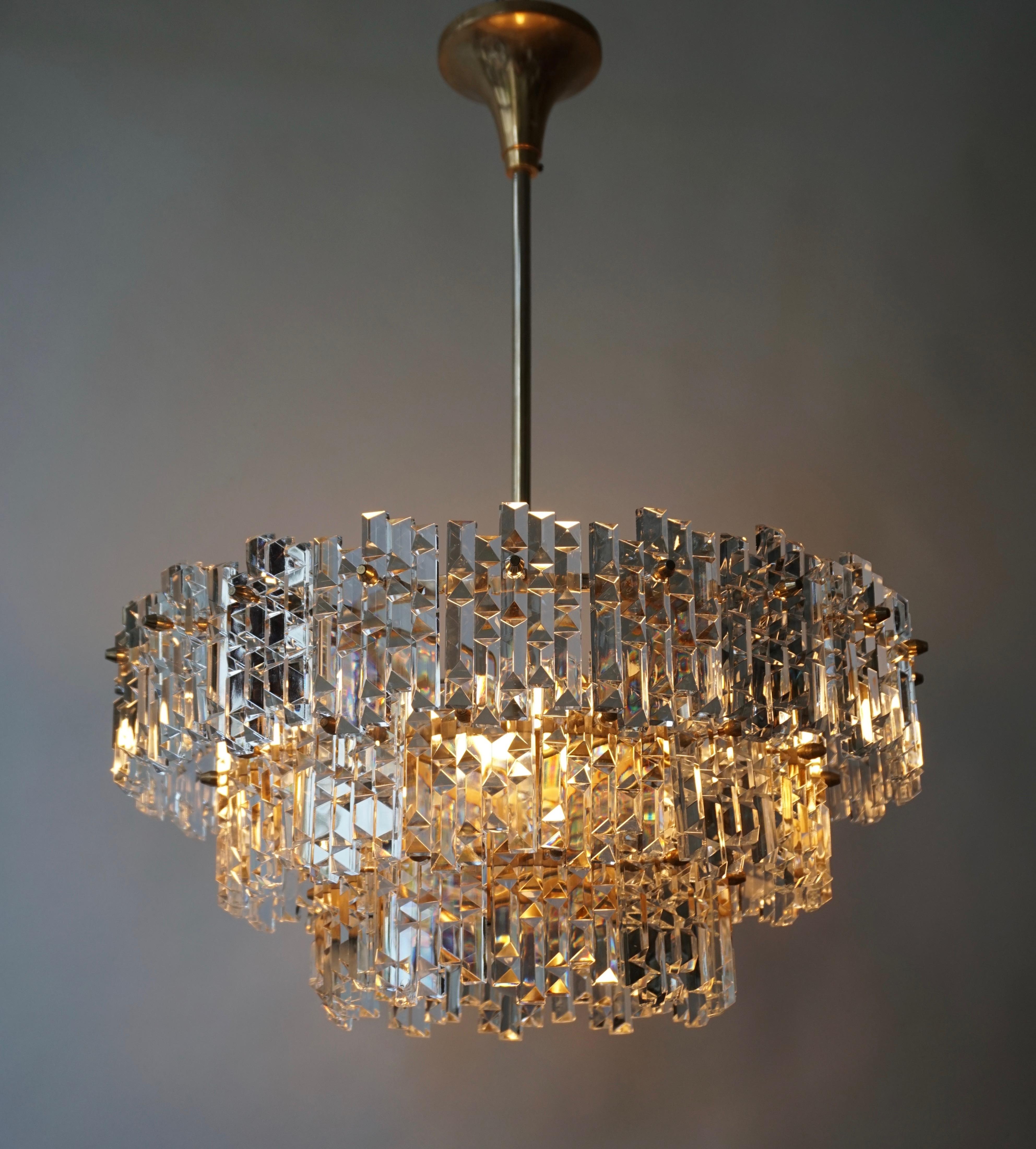 Large gilt Mid-Century Modernist Murano chandelier made in Italy, circa 1960-1970. It has 45 hexagonal diamond-shape faceted glass crystals.
Mounted on a gilt brass metal fixture. It needs 5 x E27 standard screw bulbs to illuminate. After years