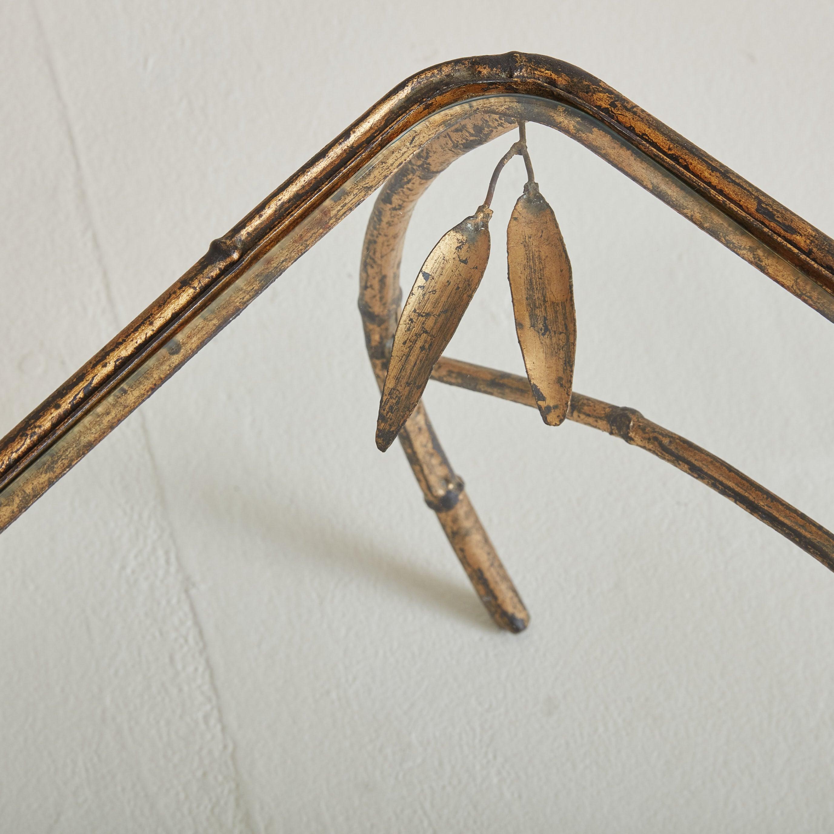 Une élégante table basse des années 1940 provenant du sud de la France. Cette pièce au design raffiné présente un cadre en laiton doré moulé dans un délicat motif de faux bambou avec des motifs de feuilles. La structure de la table est légère et