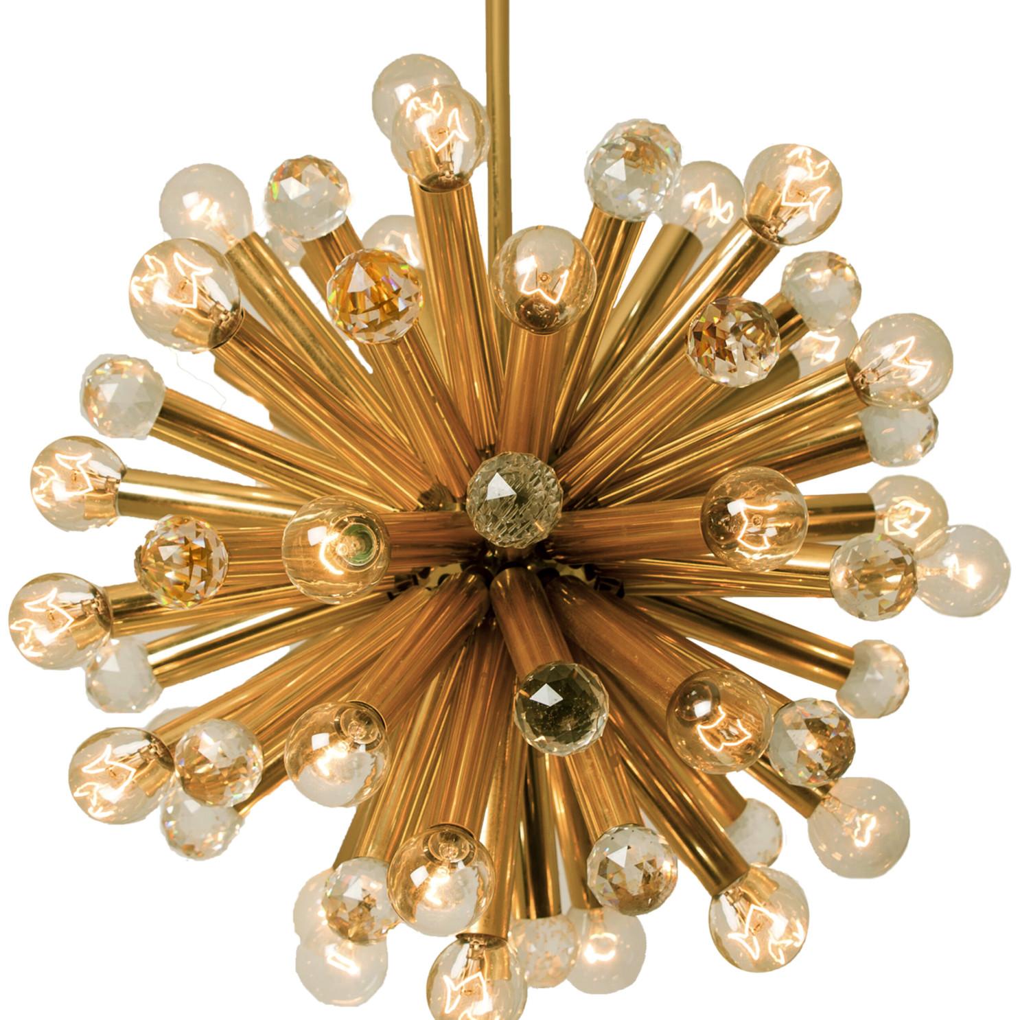 This high quality chandelier was manufactured by Ernst Palme in German Westheim during the 1960s. This lamp has gilt brass arms with large Swarovski balls and 33-light bulbs. The handcut lead crystal Swarovski balls reflect multiple colors in the