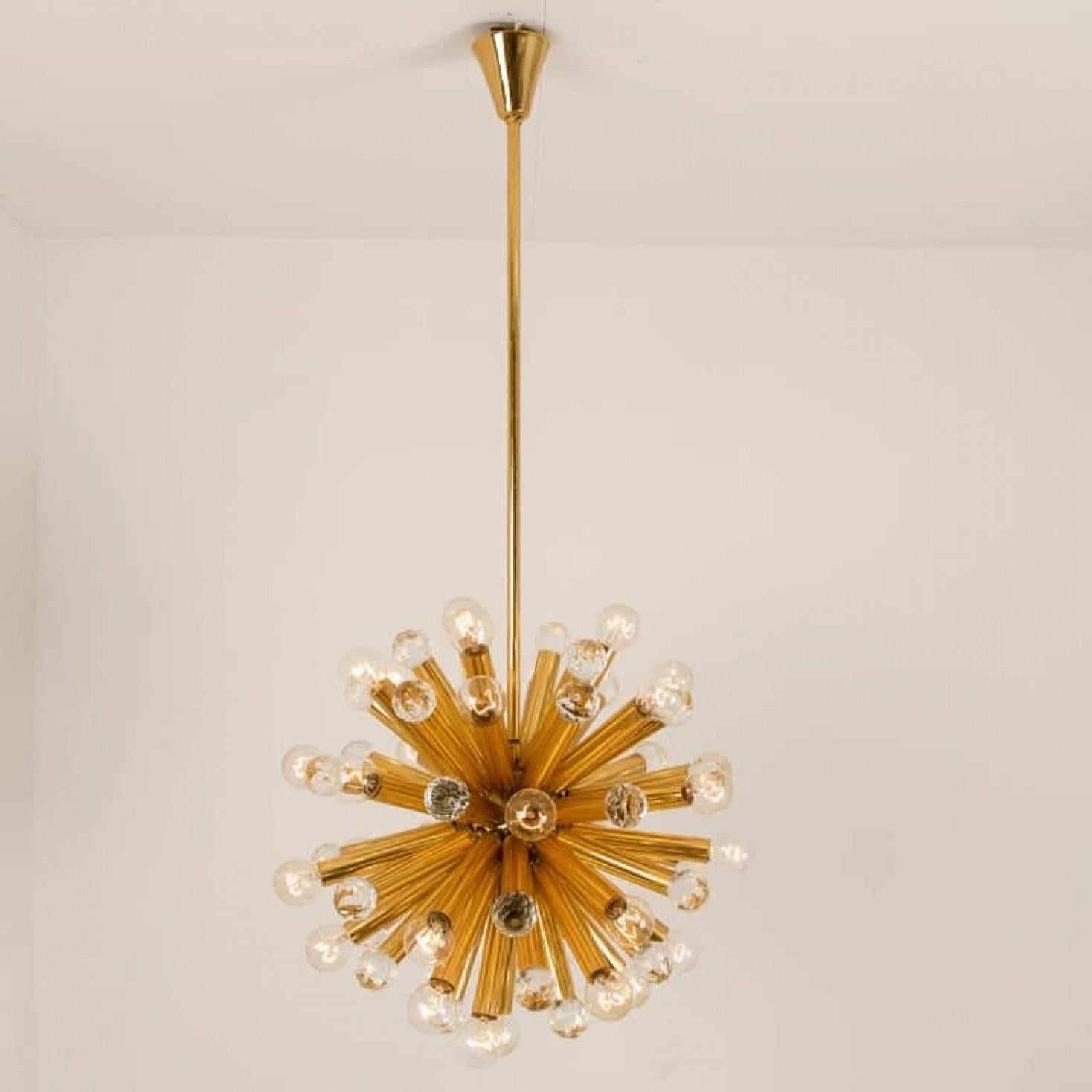This high quality chandelier was manufactured by Ernst Palme in German Westheim during the 1960s. This lamp has gilt brass arms with large Swarovski balls and 33-light bulbs. The handcut lead crystal Swarovski balls reflect multiple colors in the