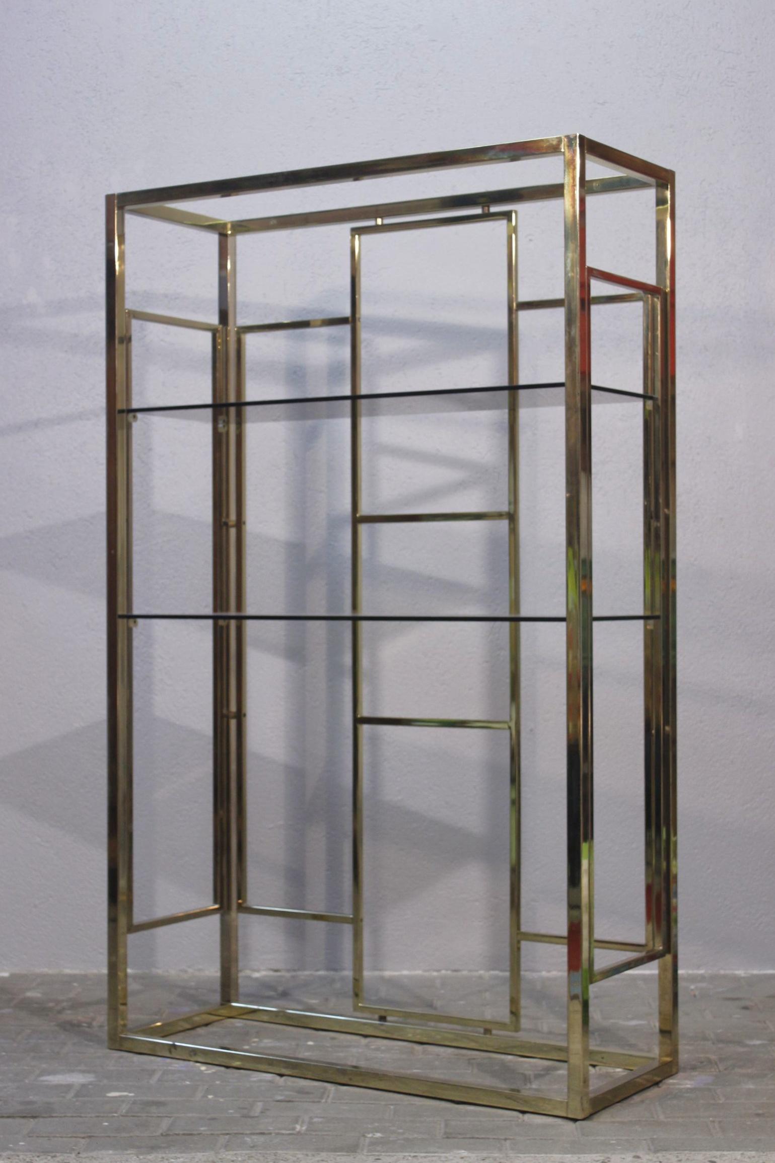 Preciosa estantería de Renato Zevi, Italia, hacia 1970; el diseño tiene esos icónicos acentos geométricos. Cuerpo de latón dorado con dos bandejas de cristal ahumado, se pueden añadir otras si se desea.

En buen estado, con pocos signos de uso.