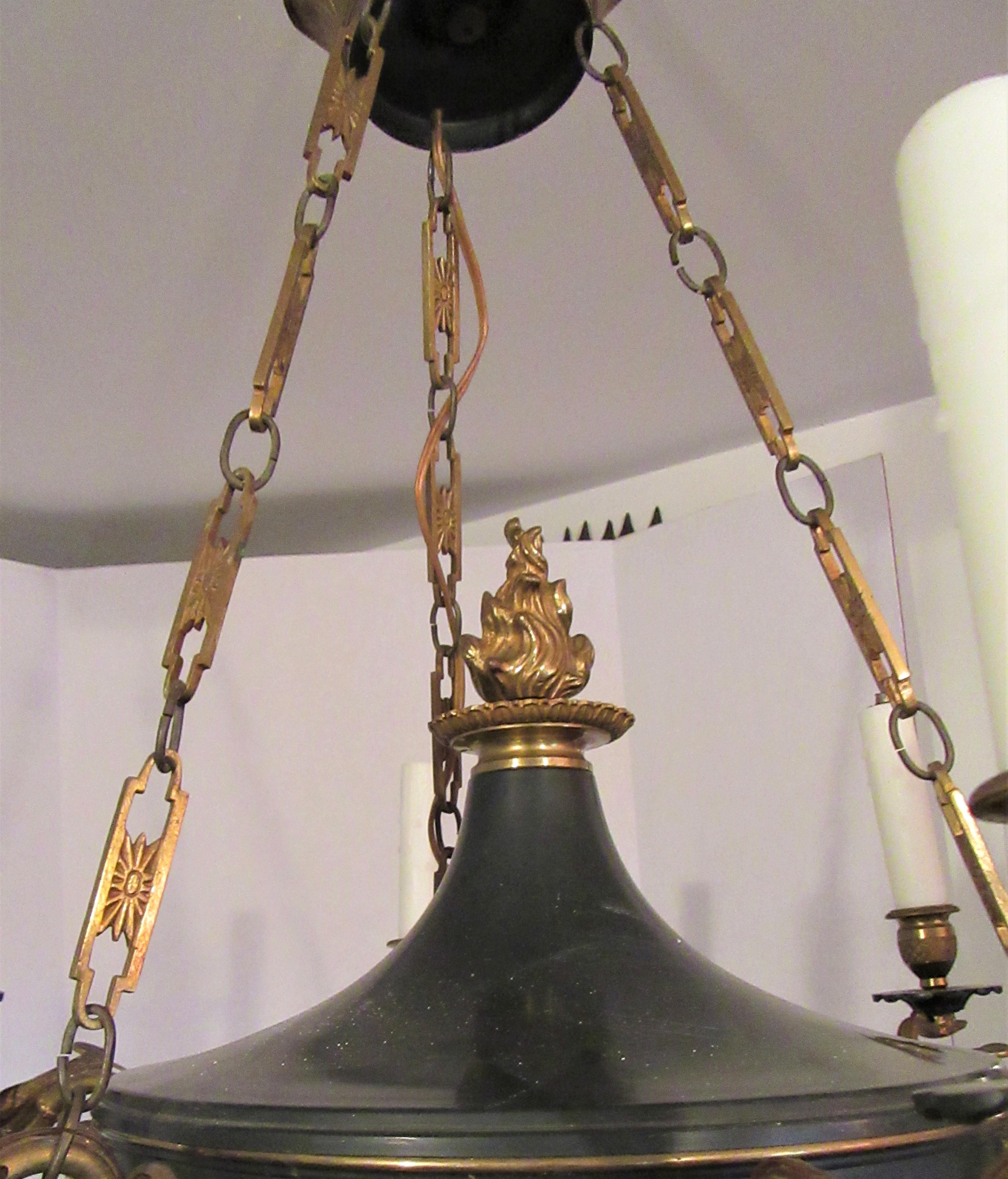 Gilt bronze and black tole six-light chandelier. Six long upturned arms with swan and foliate decoration. The tole center terminates in a central leaf and large acorn finial. Original chain and ceiling rose, good scale and nicely cast.