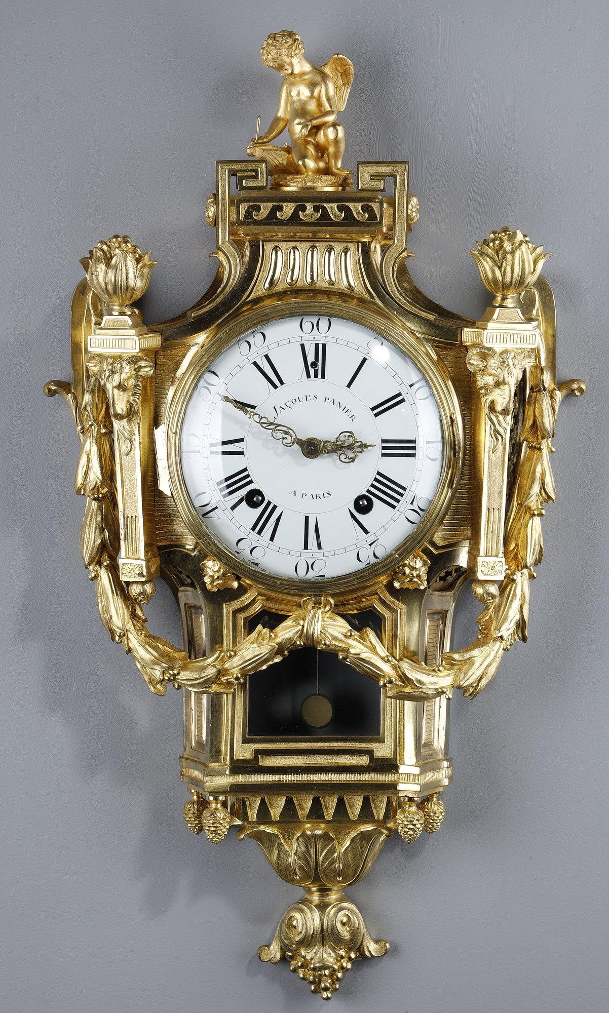 Large Louis XVI period gilt and chased bronze wall clock, signed Jacques PANIER in Paris. The body of this clock is in the form of an architectural cartouche, with a ribbed or fluted base, a molded bezel, framed by two sheaths with goat heads and