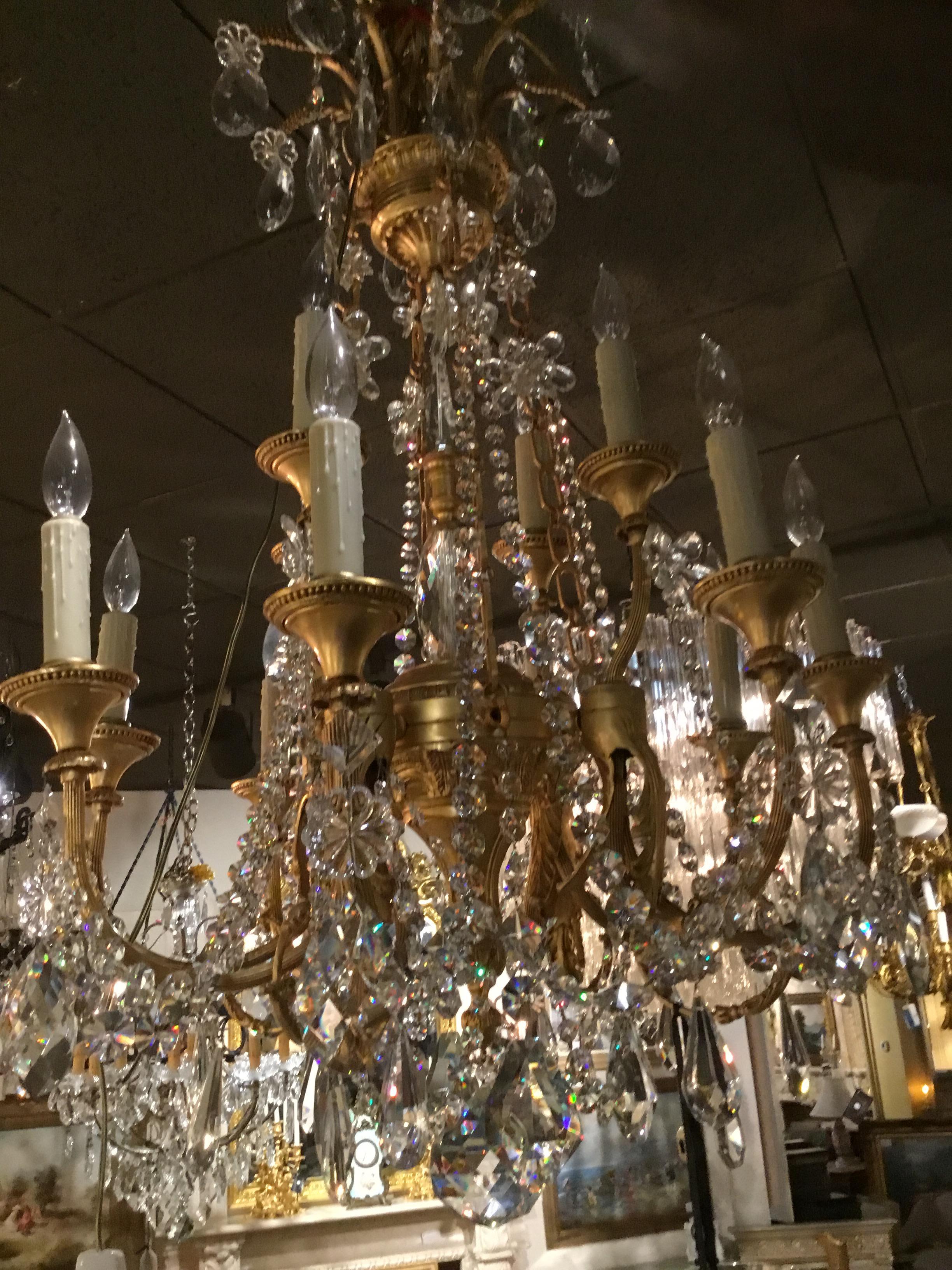 Gilt bronze crystal chandelier with a central crystal spire having
12-light. The patina is a lovely brilliant color and the crystal reflects
Beautiful color.
    