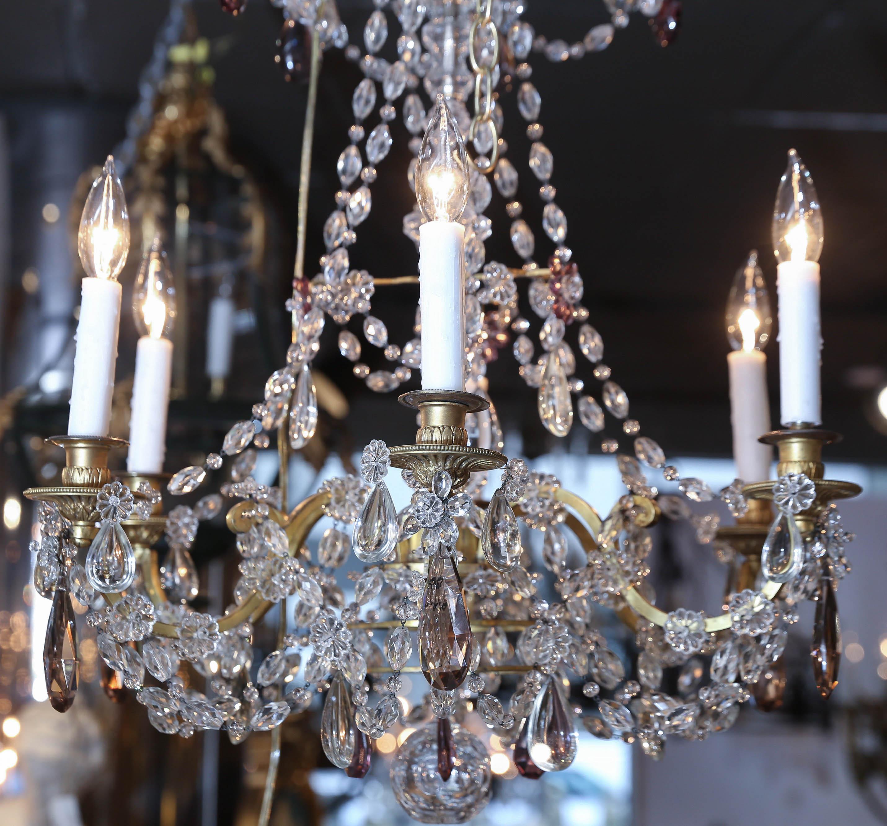 Lovely petite chandelier in the Marie Antoinette style with clear crystal
And accented with amythest and bronze crystals. It has 6 lights. Wiring 
Is in very good condition and ready to hang. It has scrolling arms in
Gilt bronze with a beautiful