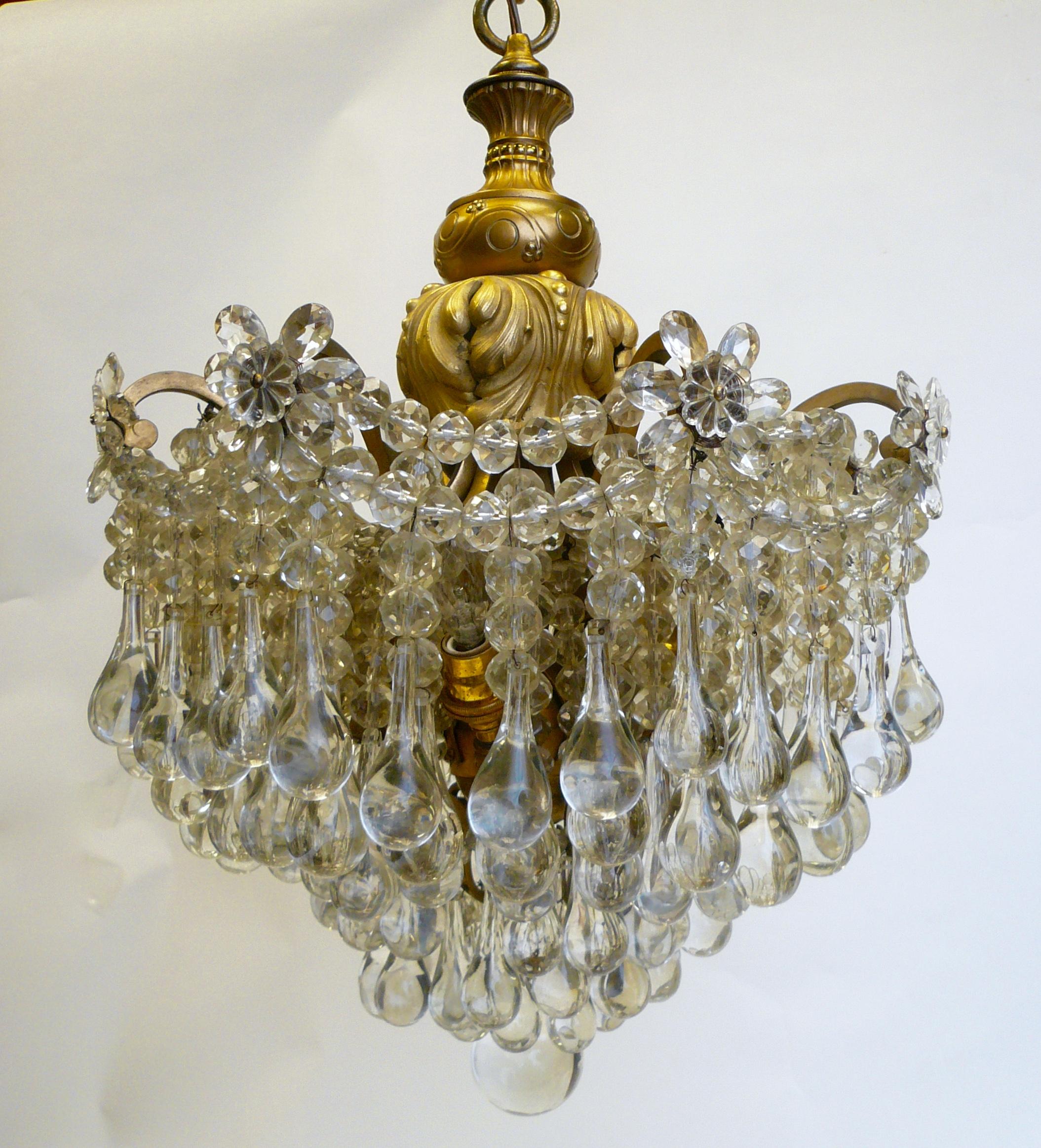 This exuberant pendant fixture features graduated swags of faceted beads densely hung with blown crystal drops. The gilt bronze frame is finely cast, and features neoclassical motifs.