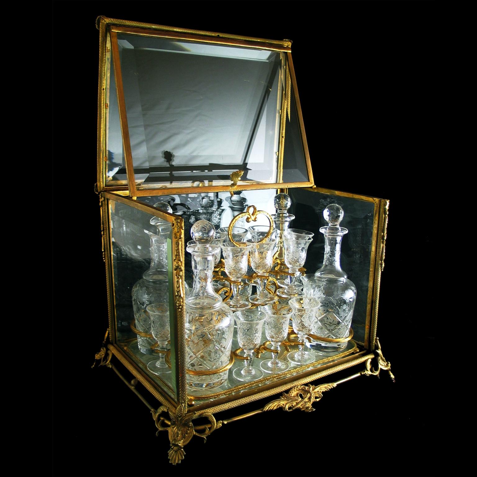 A fine and decorative gilt-bronze and cut-glass decanter set by La Compagnie des Cristalleries de Baccarat.

The set consisting of four decanters and sixteen glasses each finely facet cut and wheel engraved on a lift out gilt-bronze and mirrored