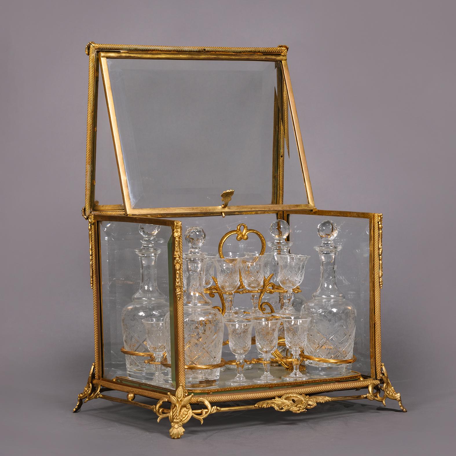 A fine and decorative gilt-bronze and cut-glass decanter set by La Compagnie des Cristalleries de Baccarat.

The set consisting of four decanters and sixteen glasses each finely facet cut and wheel engraved on a lift out gilt-bronze and mirrored