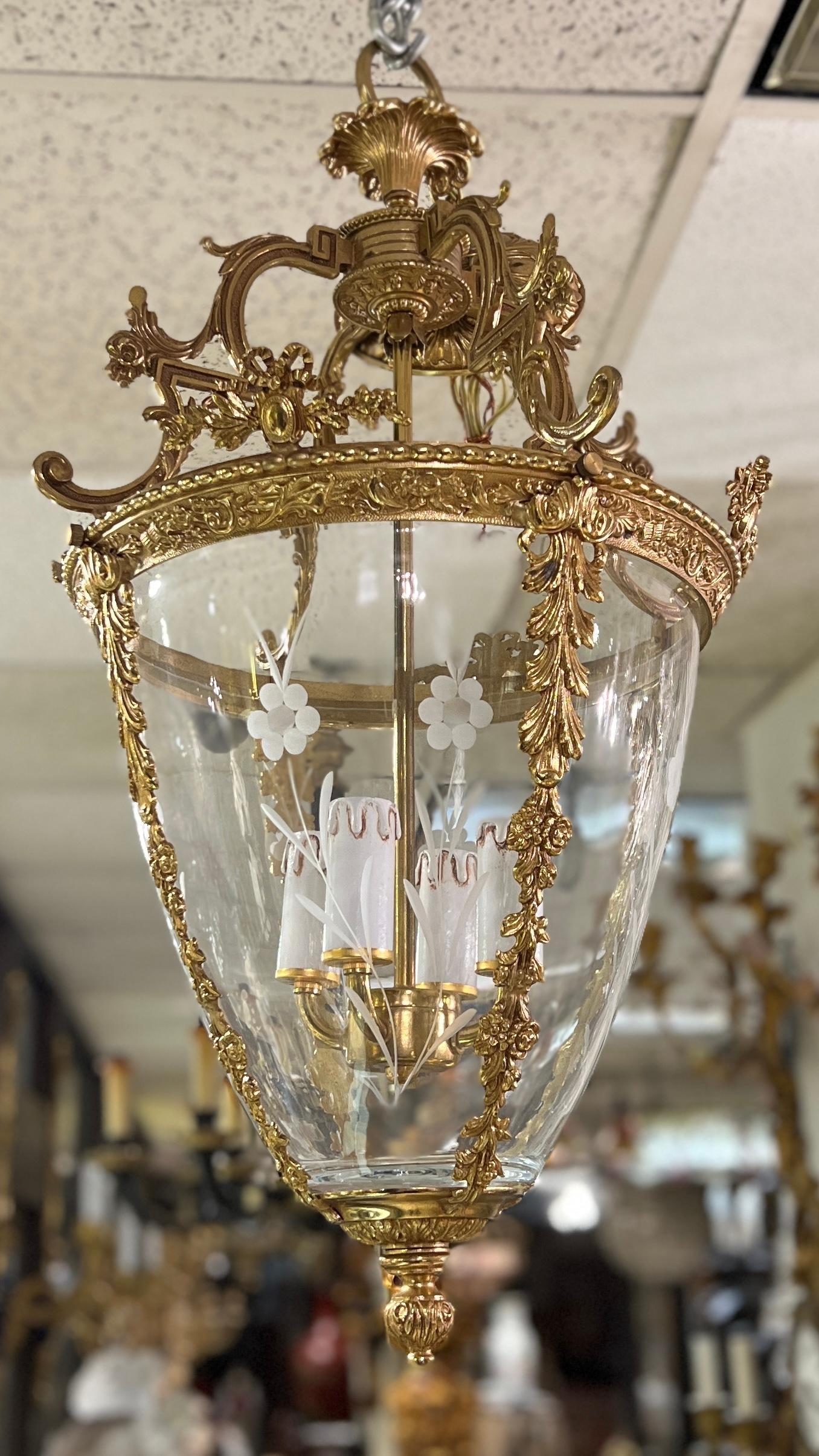 Eccezionale lanterna in bronzo dorato e vetro in stile Luigi XVI francese, con quattro prese elettrificate e motivi neoclassici finemente fusi, tra cui festoni fogliacei, fiori, acanto, trombe e covoni di grano, vetro inciso a fiori e la piastra da
