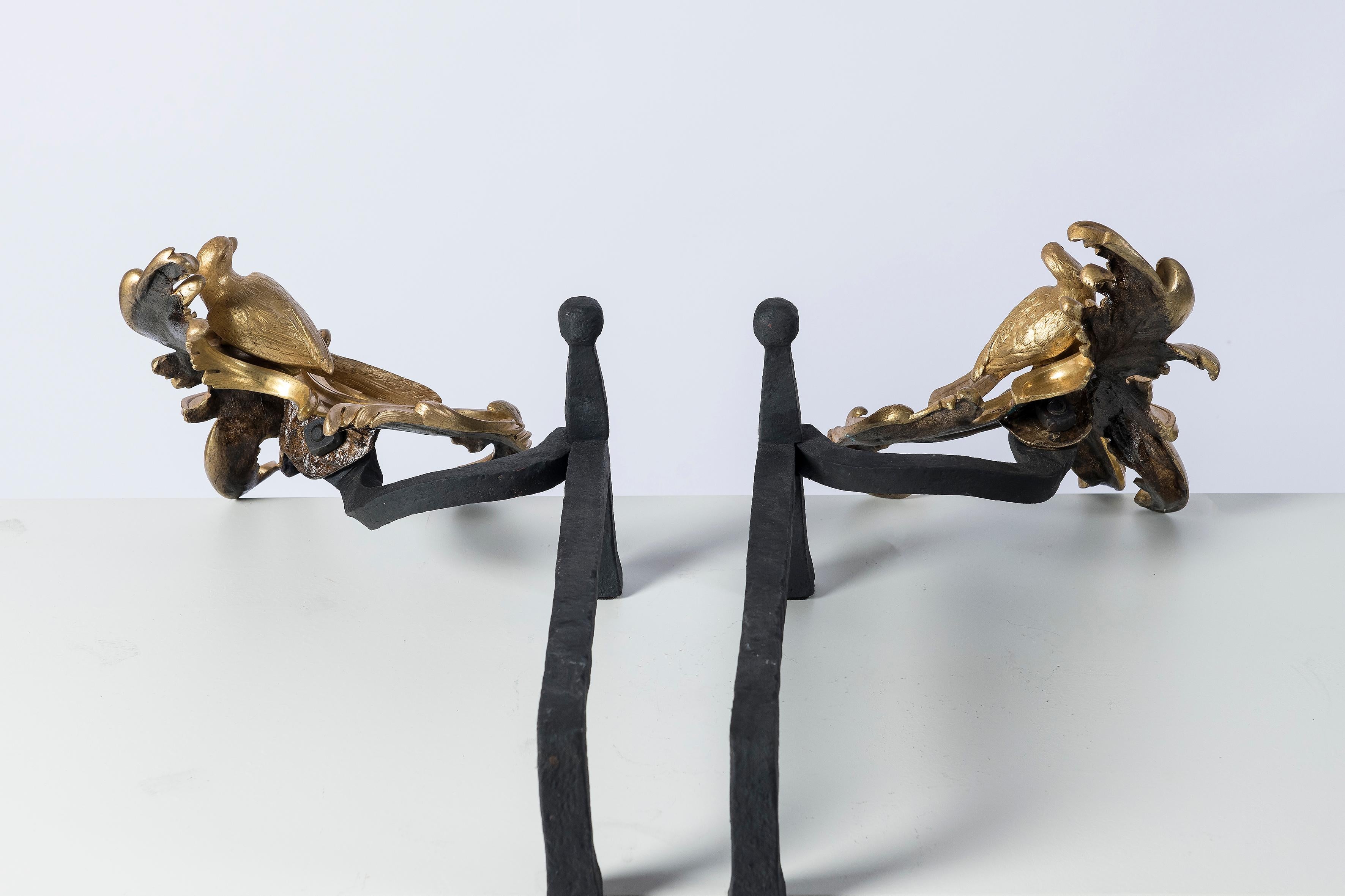Gilt bronze and iron andirons with bird figures. Louis XV style, circa 1890.
With iron log holders behind.