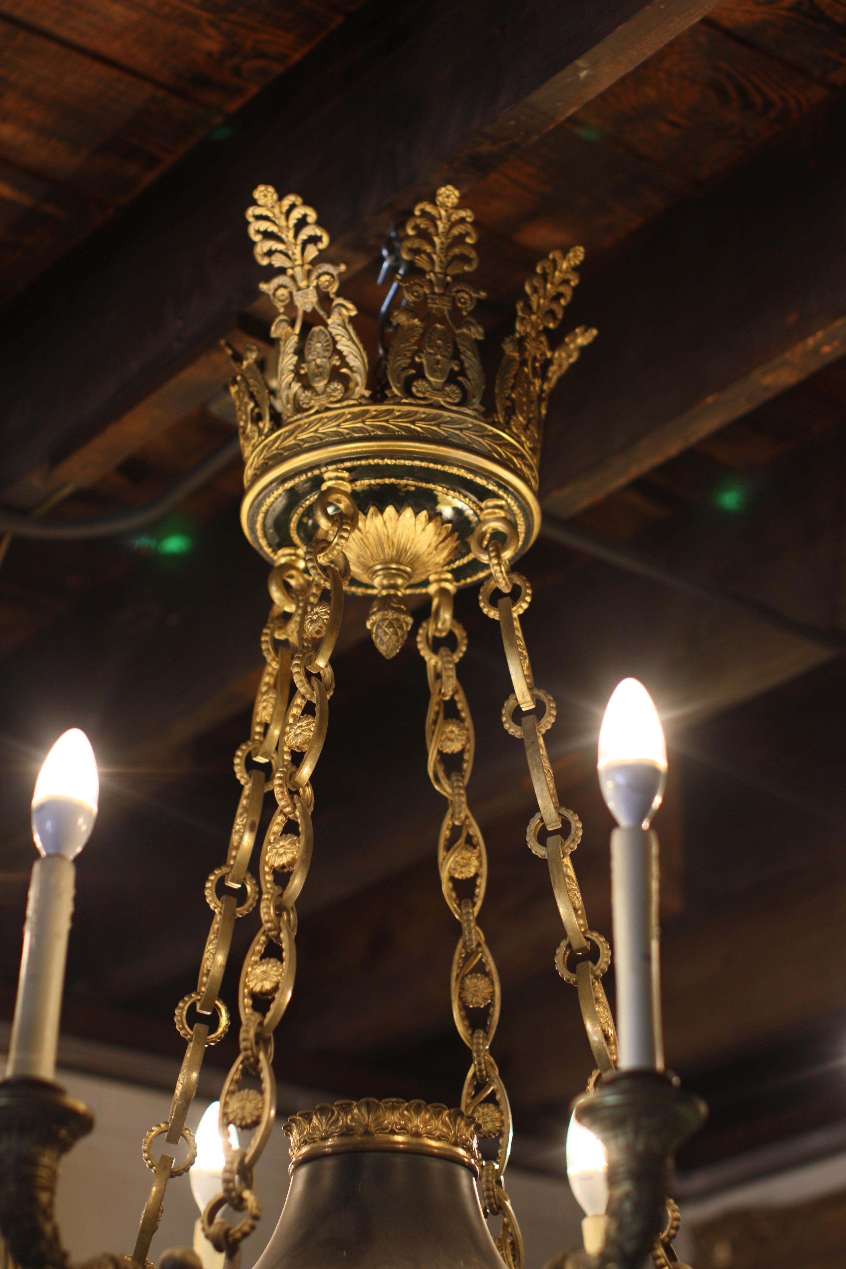 An Empire style very finely chased gilt-bronze and patinated bronze eight-light chandelier, French, circa 1880.
Measures: Height 46 in. (116.84 cm.), diameter 37 in. (93.98 cm.)