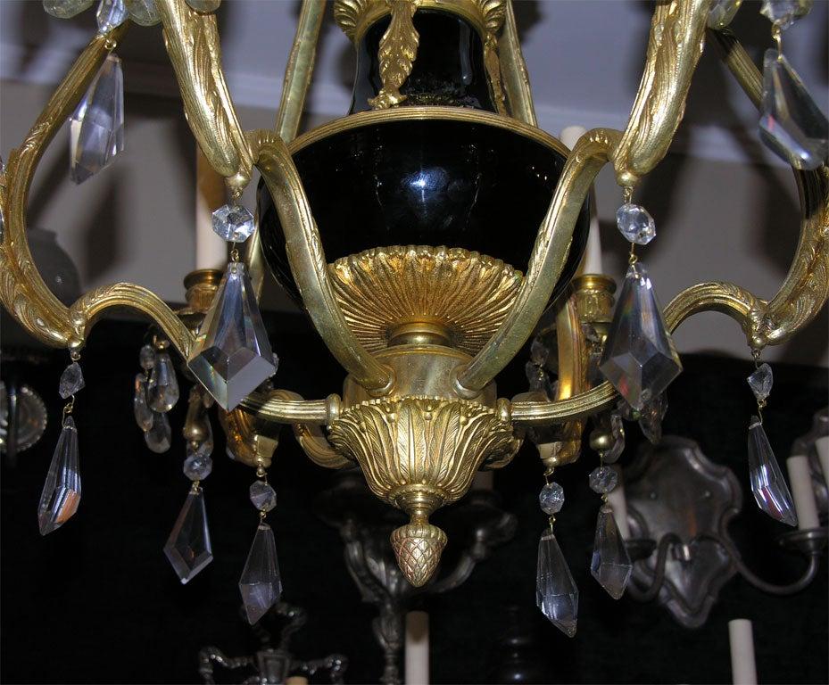 Un lustre à 6 bras en bronze doré français datant d'environ 1900 avec un centre en vase de porcelaine et des fleurs en porcelaine peintes à la main.

Mesures :
Hauteur : 34