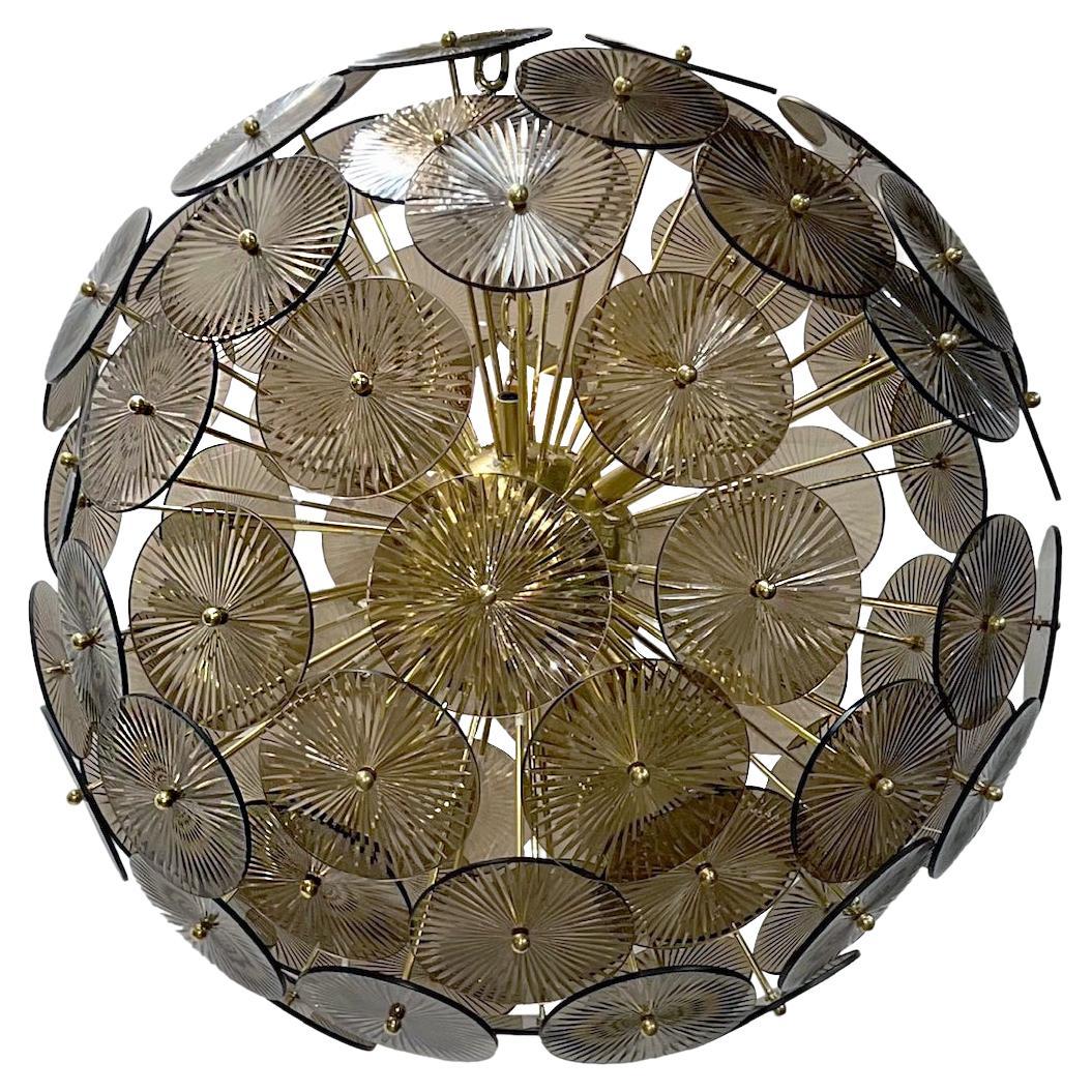A circa 1960s Italian Moderne style sputnik light fixture with smoke colored glass fittings. The frame in a gilt bronze. 12 Lights.

Measurements:
Minimum drop: 33