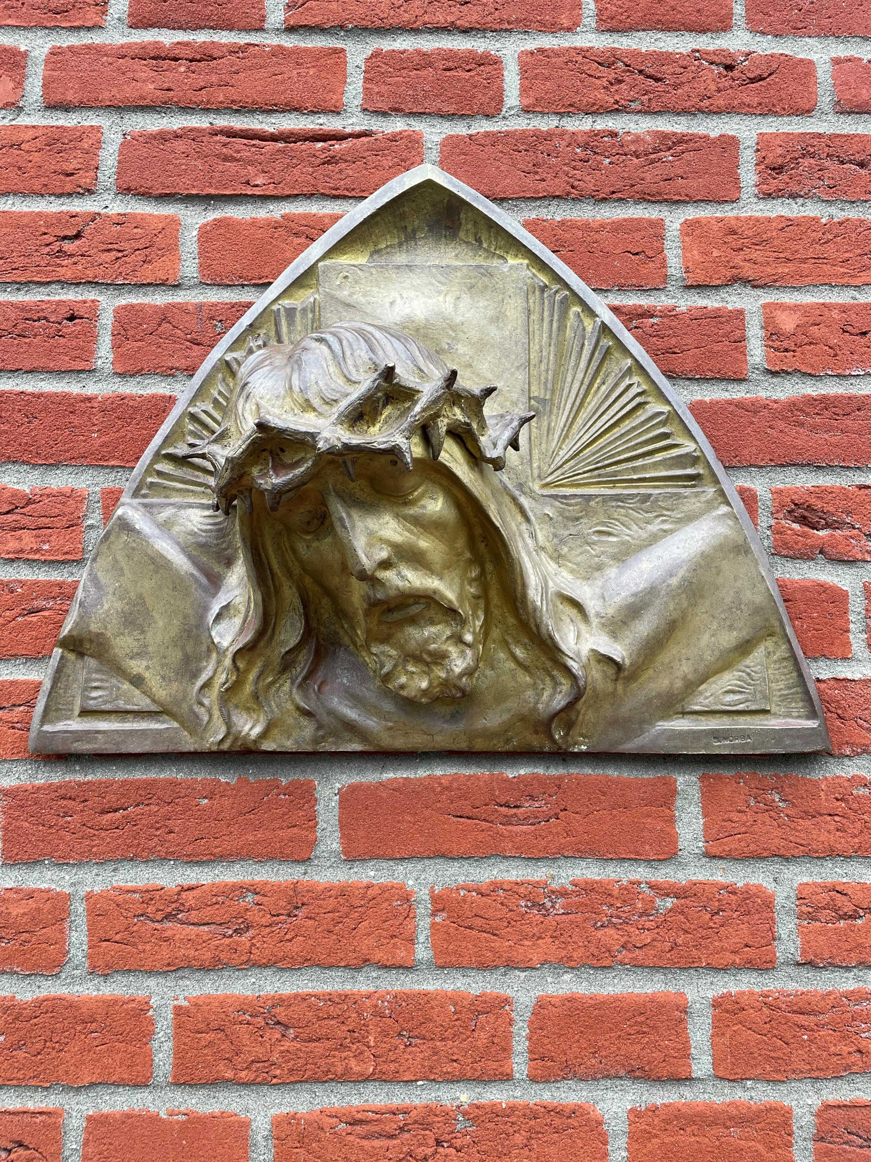 Impressive and sizeable sculpture of Christ with a gruesome crown of thorns.

This striking sculpture of Christ on a rounded triangle wall plaque dates from the 1920s. This bronze actually is the deepest in relief by Sylvain Norga that we have