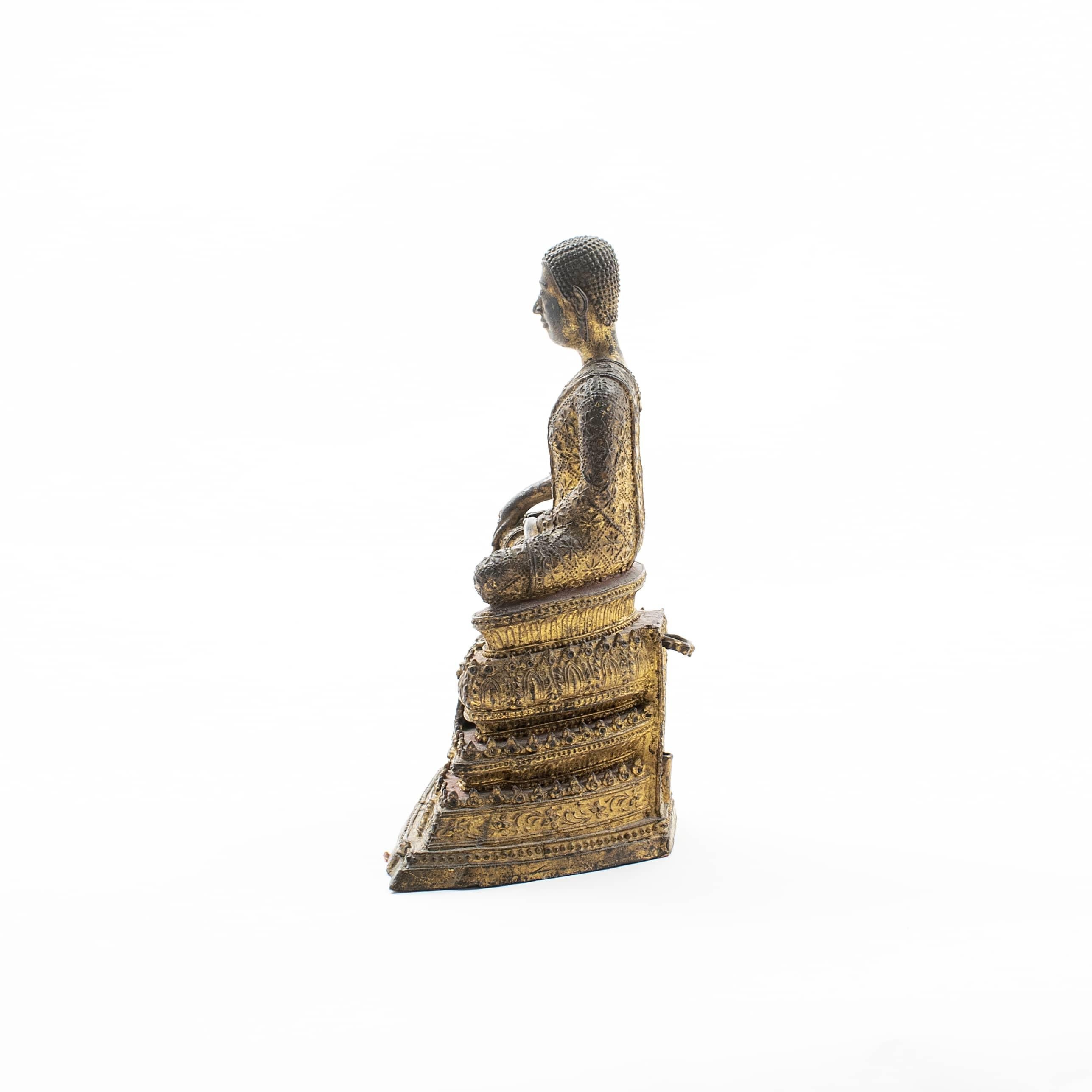 Gilt bronze Buddha figure seated in Bhumisparsha mudra position* (“calling the earth to witness”).
The Buddha sits upon a high gilt and red lacquer stepped platform.
Original untouched condition with a very beautiful age-related patina.

Siam,