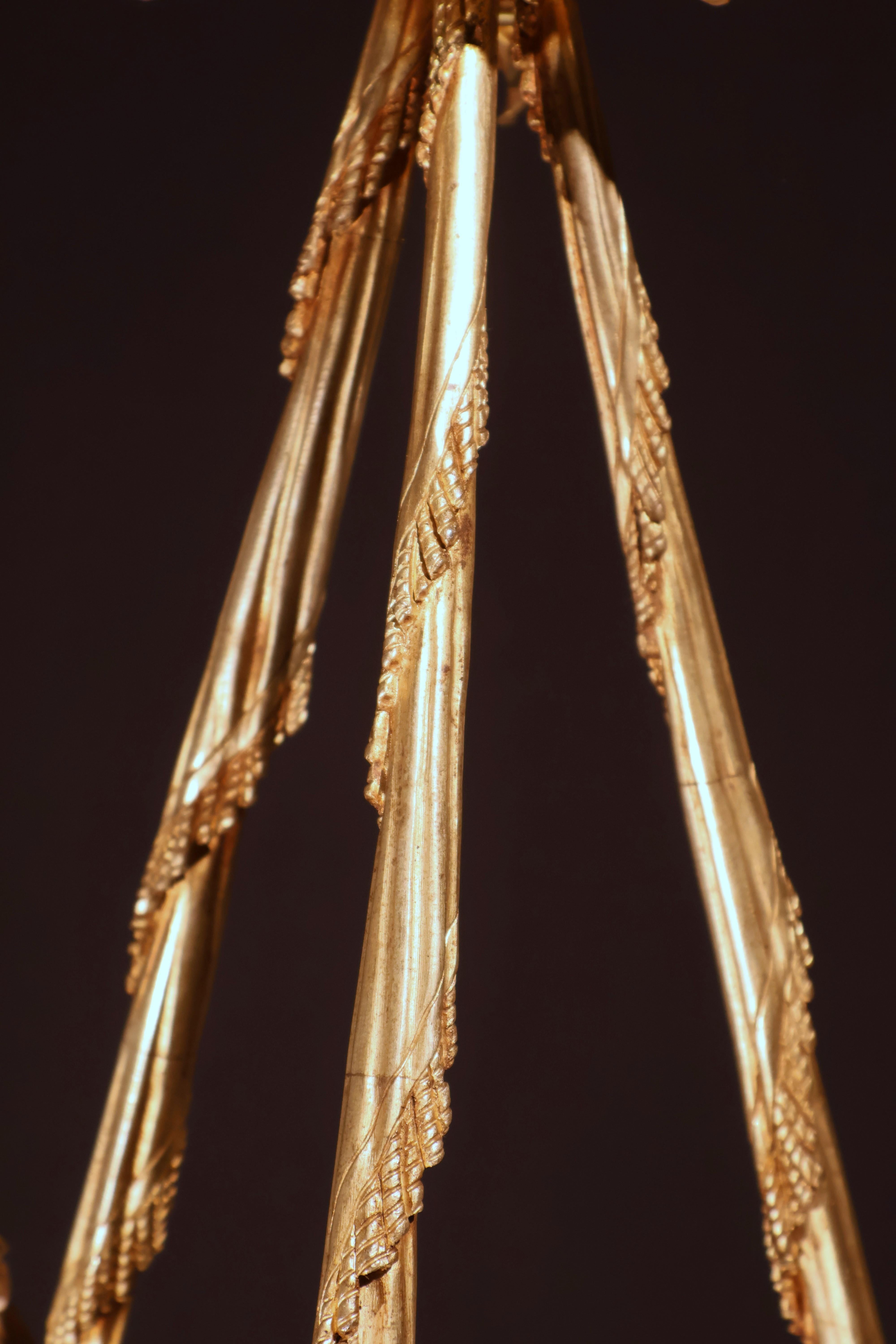 Araña de bronce dorado que representa a un Querubín sosteniendo una antorcha y una corona de flores diversas. Francia, hacia 1900. 6 luces. 
Dimensiones: Altura 30