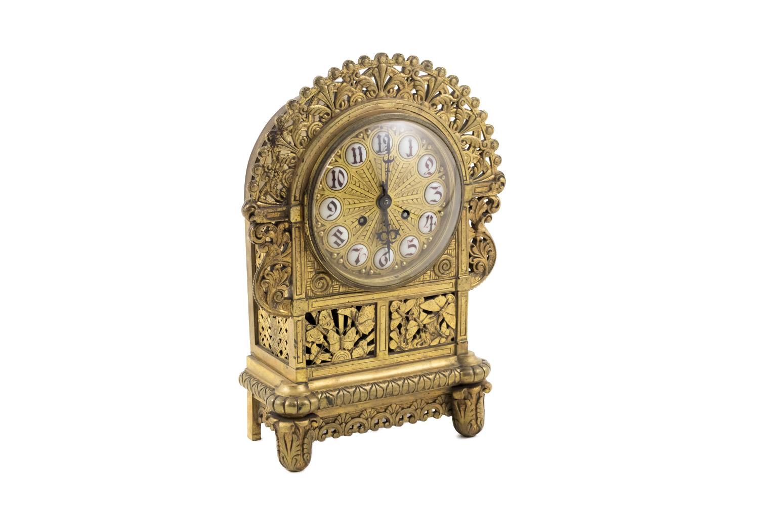Gilt bronze clock with a case with floral and foliage motifs. Base with two front oval foot with wounded leaves motifs and two straight back foot with a rectangular shape linked each other, on three sides, by a C scrolls frieze and stylized palm