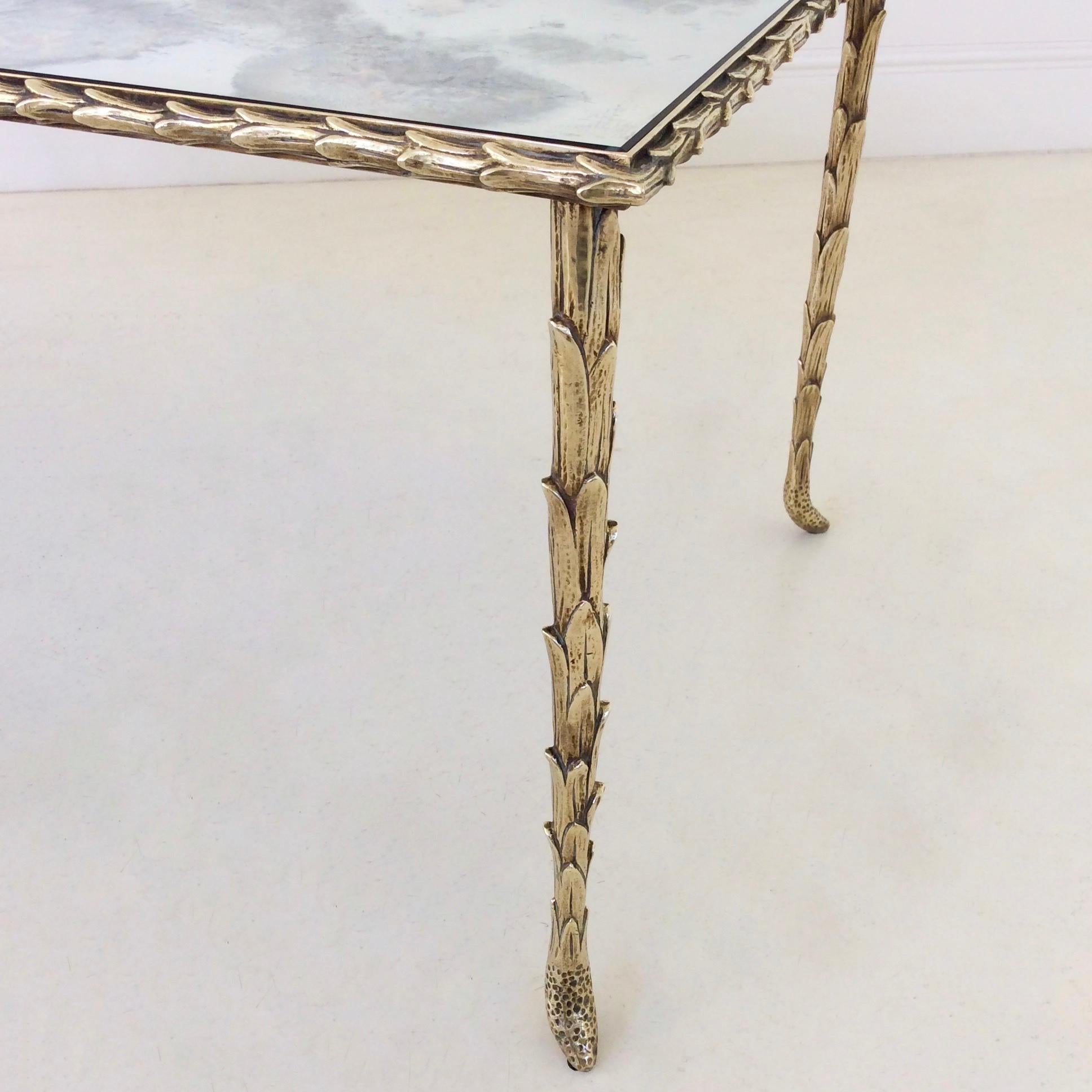 Nice gilt bronze coffee table by Maison Baguès, circa 1950, France.
Palm trunk motif frame and oxidized mirror.
Dimensions: 102 cm W, 48 cm D, 40 cm H.
Good condition.
  