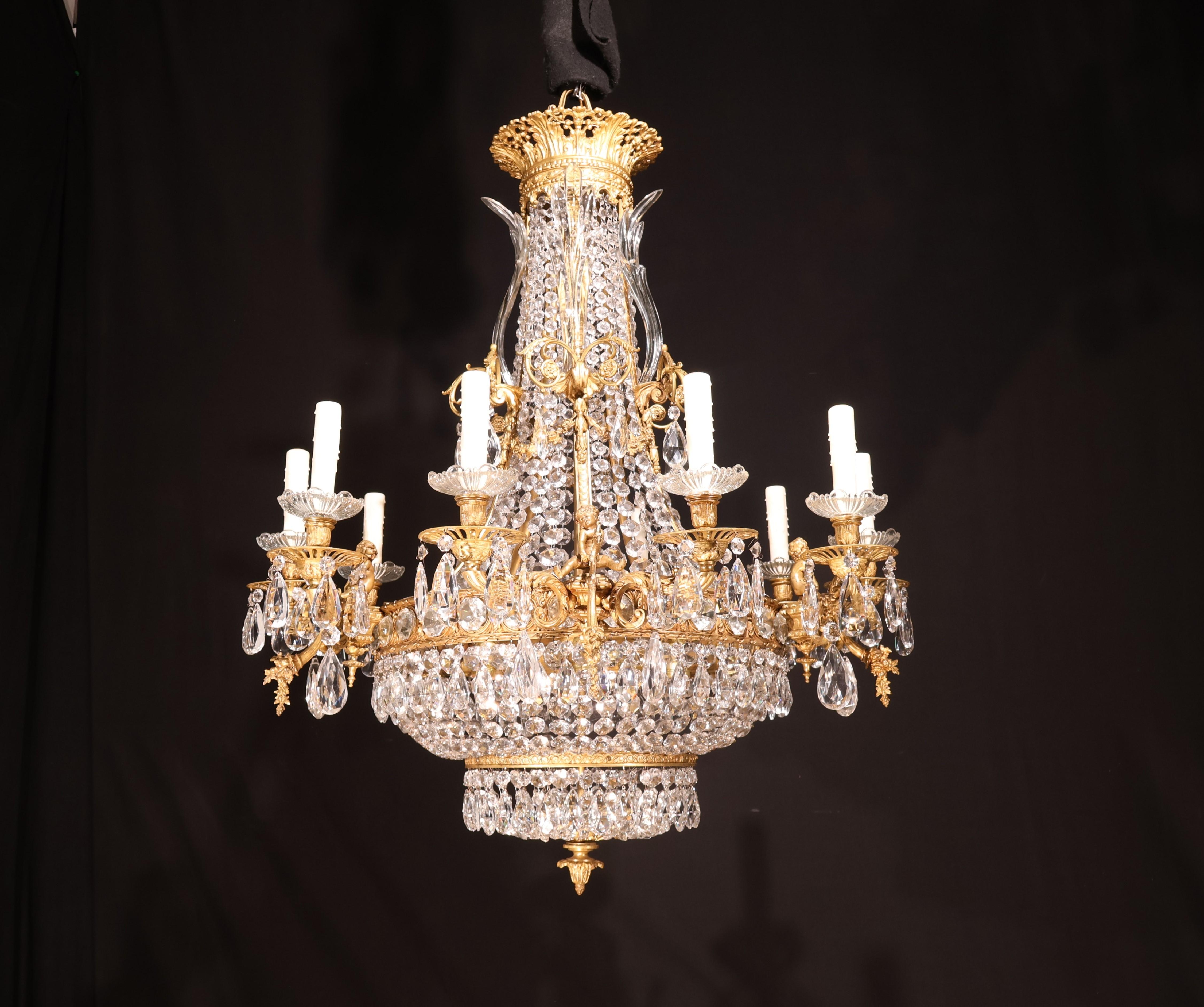A Fine Gilt Bronze & Crystal Chandelier featuring long crystal petals & frolicking cherubs spilling an hour of plenty. France, circa 1920. 18 lights. 
Dimensions: Heigth 44