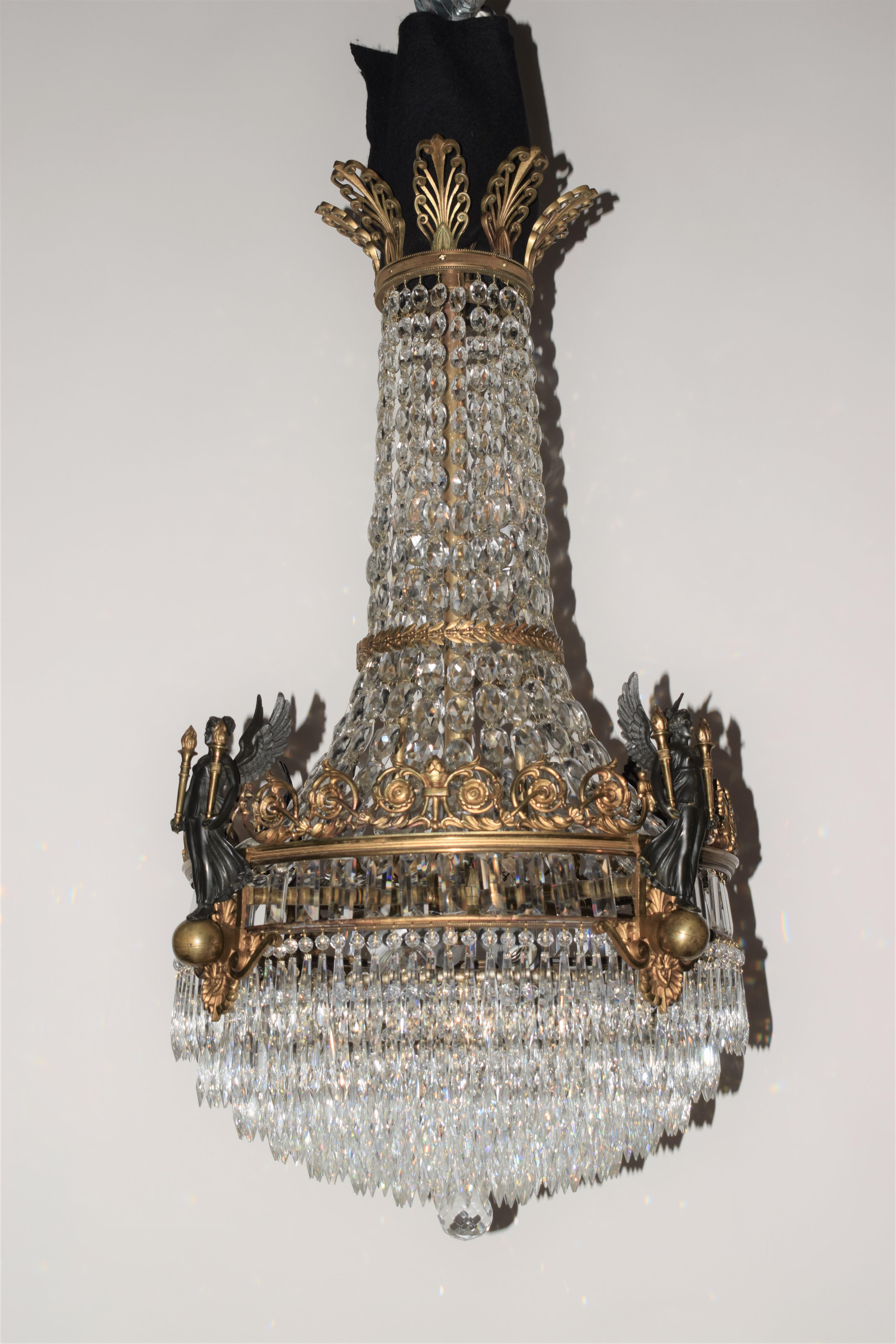 A Superb gilt bronze & crystal Empire style Chandelier. Top ring featuring anthemia. Main ring with winged deity carrying gilt torcheres. The bottom part consists of seven concentric circles of faceted drops. France, circa 1910
CW4938.