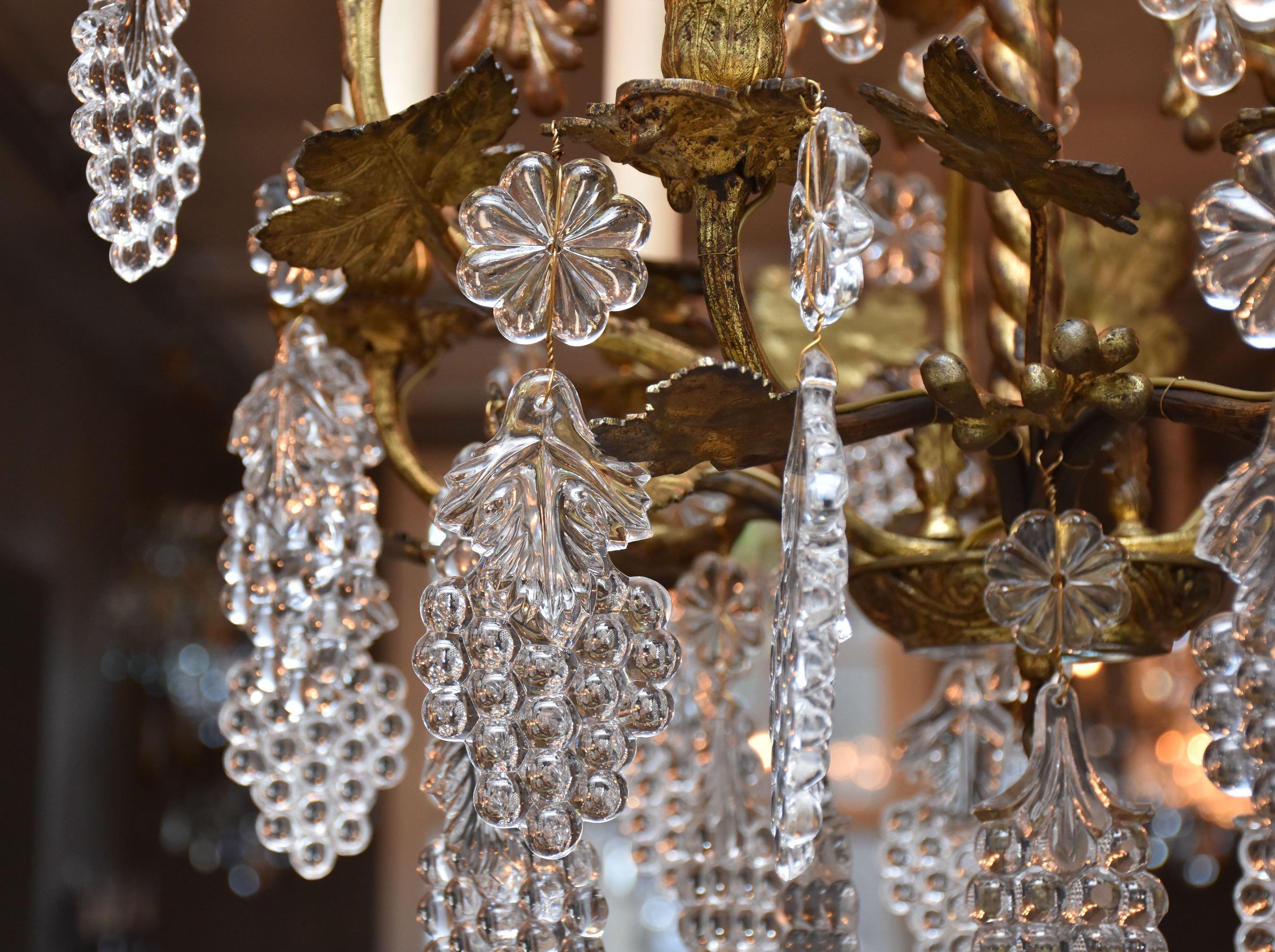 Ein wunderschöner 6-flammiger französischer Kronleuchter aus vergoldeter Bronze.
Verziert mit Weinblättern, Ranken, Kristalltrauben und großen Blumenrosetten.
Unter dem Kronleuchter befindet sich eine geschliffene Kristallbirne.
Herkunftsort -