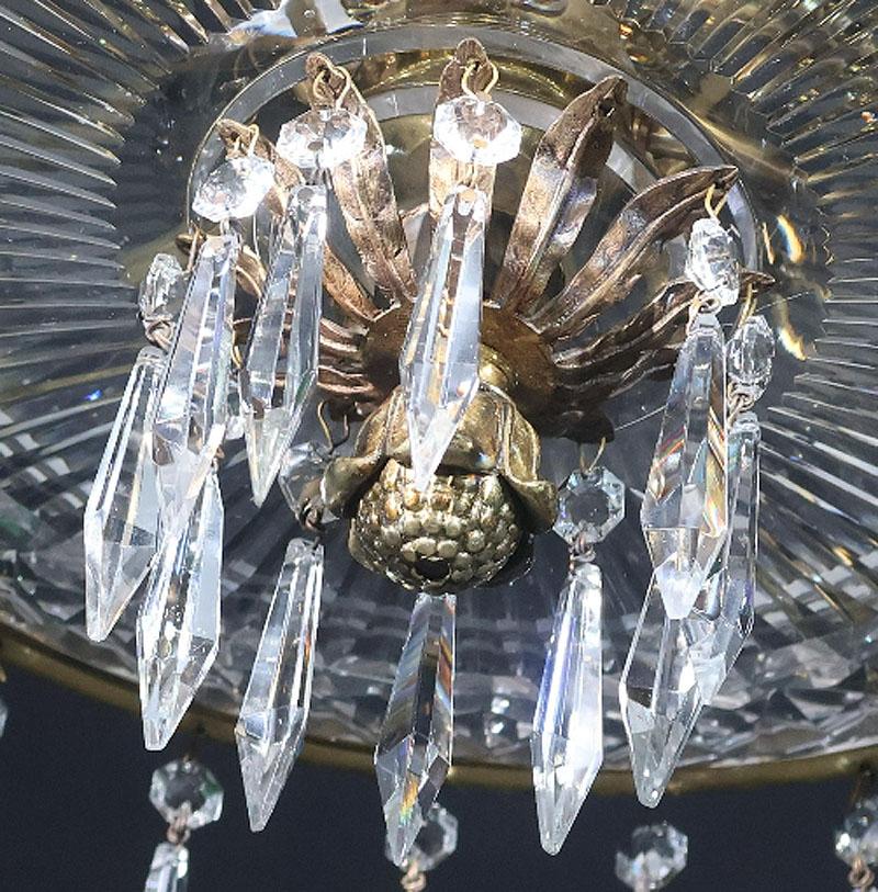 Un piatto in ormolu e cristallo tagliato di alta qualità della prima metà del secolo, appeso con gocce sfaccettate, al centro un'urna ornamentale stilizzata. Il tutto sospeso da quattro catene collegate. Piatto in crosta con terminale a foglia