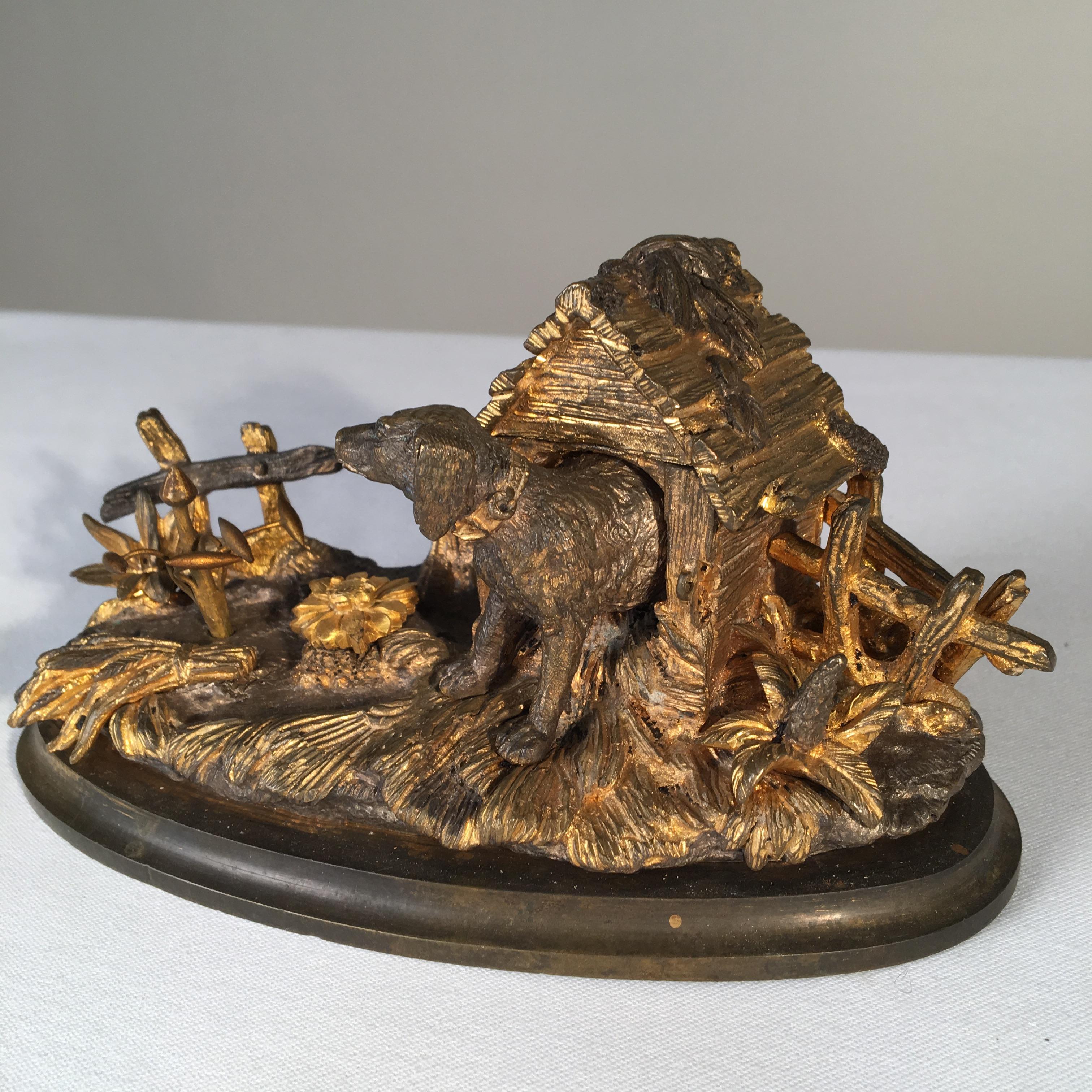 A charming French gilt bronze inkwell in the form of a dog house with the roof on a hinge to store the ink bottle.