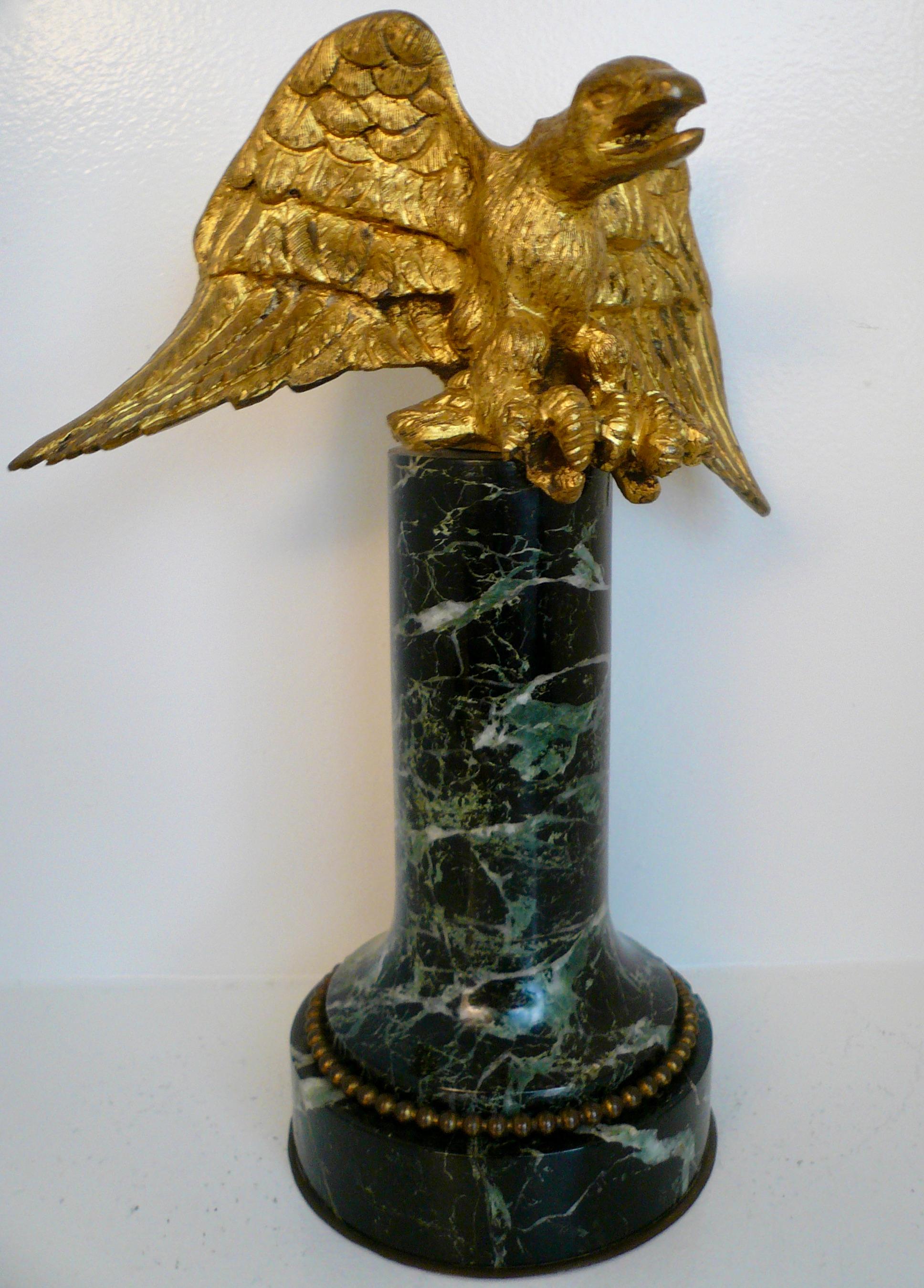 This sculpture features a gilt bronze eagle with outstretched wing atop a green marble column.