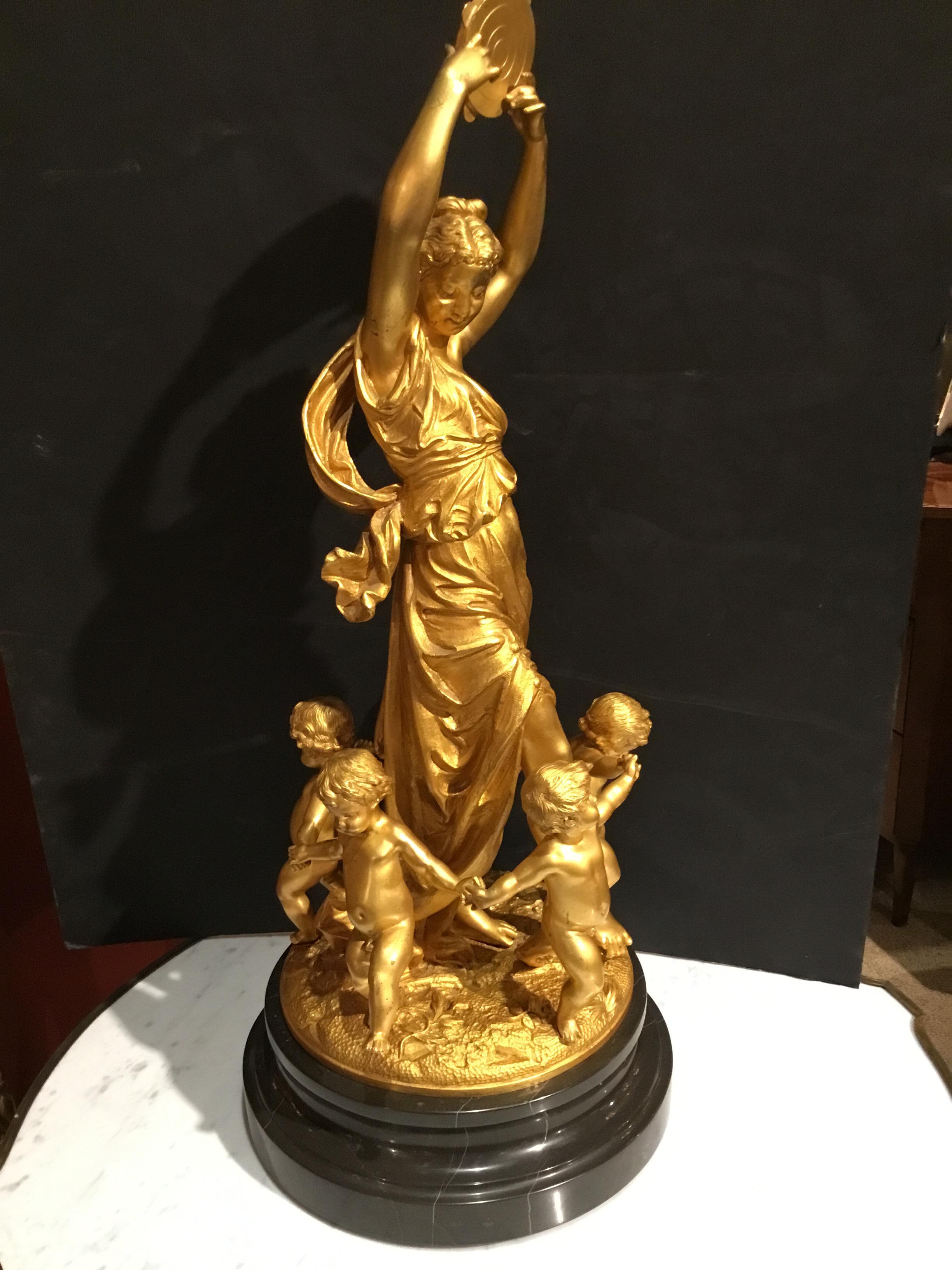Exceptional gilt bronze of a beautiful woman with a tambourine encircled by frolicking 
Children.