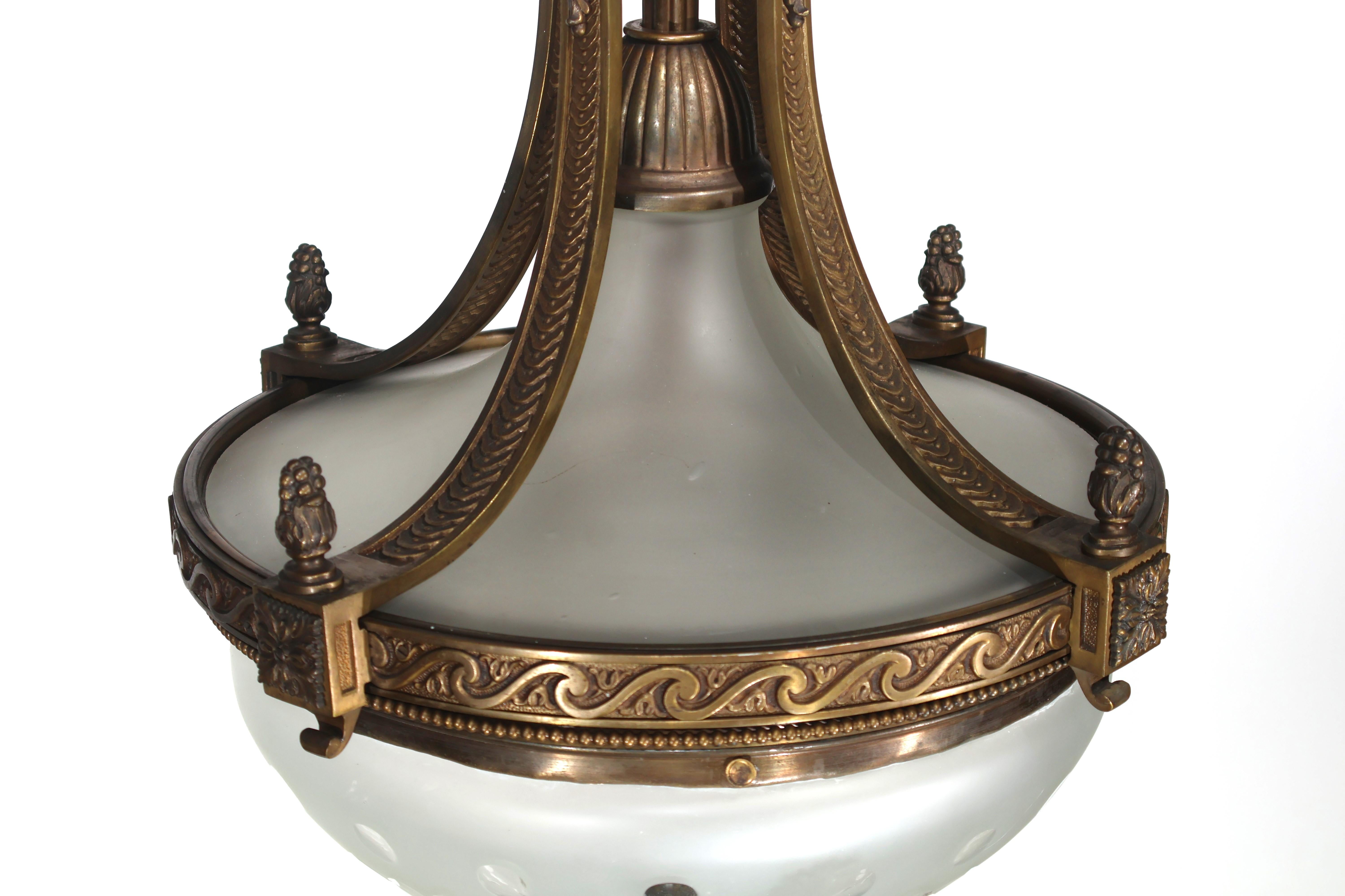 Ein sehr eleganter Kronleuchter aus Gitl-Bronze im Louis-XVI-Stil, mit einer Kuppel aus Milchglas und einer trichterförmigen Abdeckung oben. Frankreich, um 1920.
Abmessungen: Höhe  30