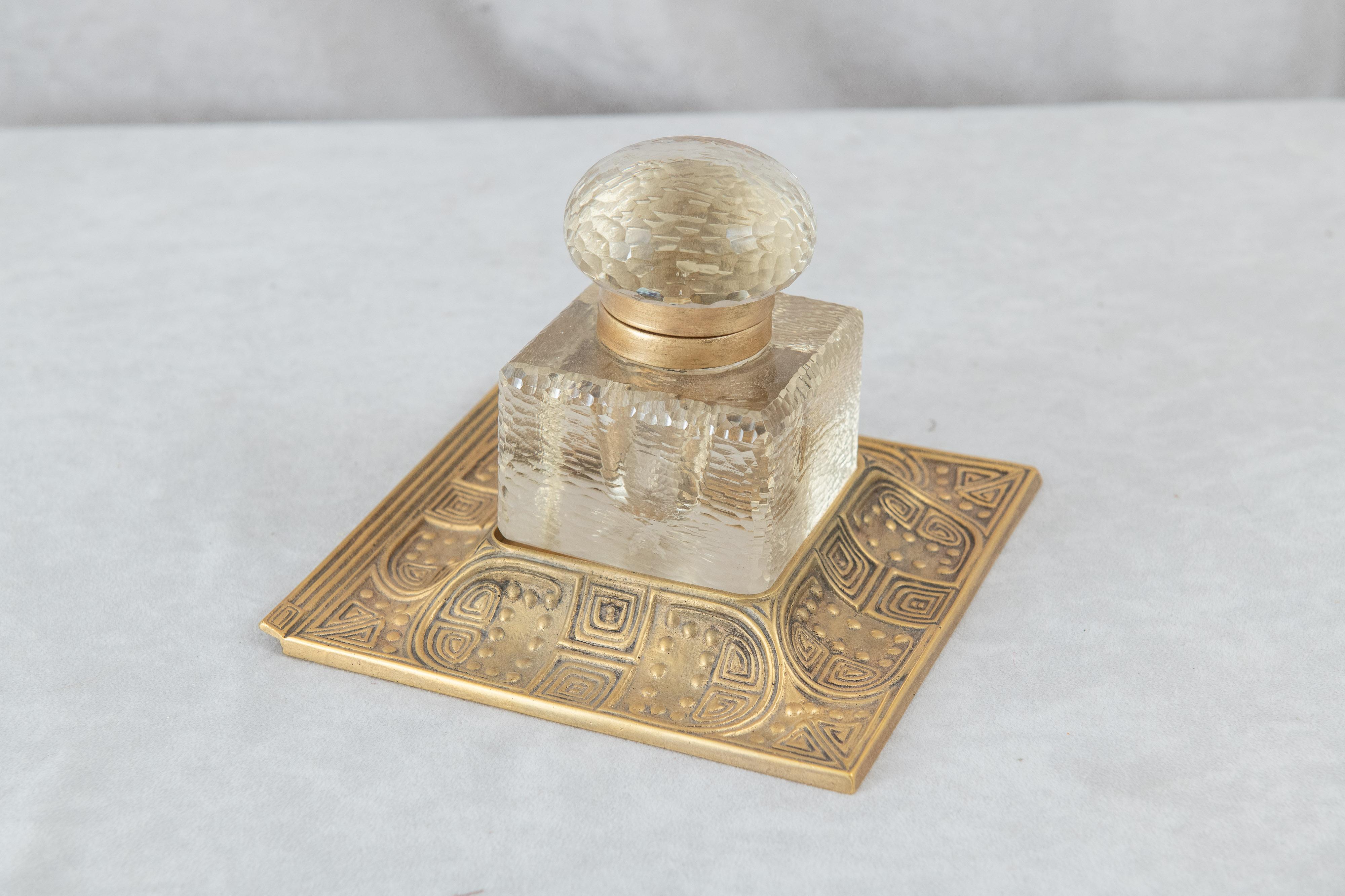   This very handsome gilt bronze and glass inkwell will make any desk look important. Signed, Tiffany Studios guarantees quality. The design is of the metalwork is striking and the glass inkwell is very heavy and beautifully detailed. A very
