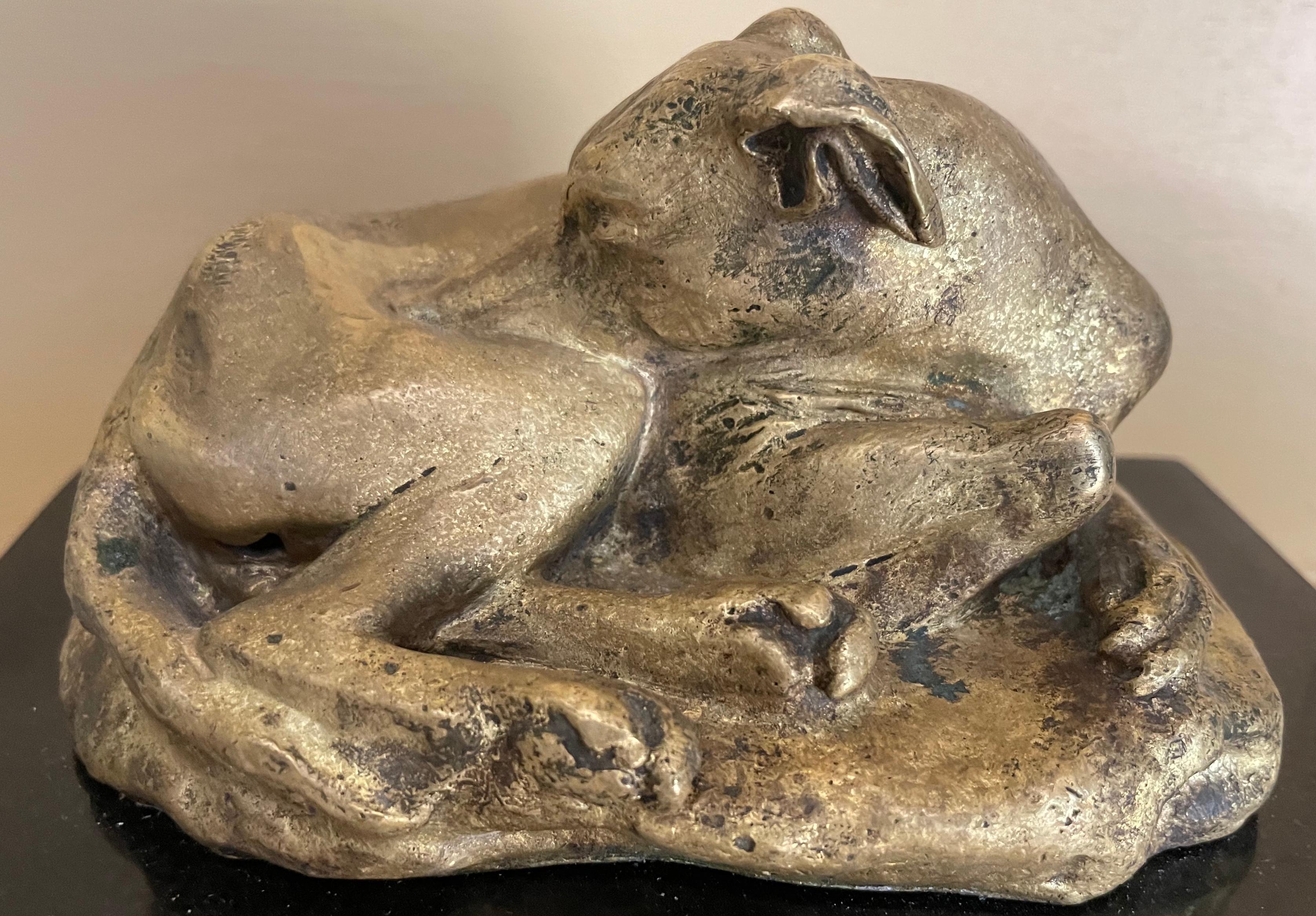 Sculpture de chien lévrier en bronze doré. Elegant lévrier italien whippet reposant sur un socle rocheux grossièrement modelé en bronze patiné or doux sur épais socle de marbre noir. Estampillé au recto, 