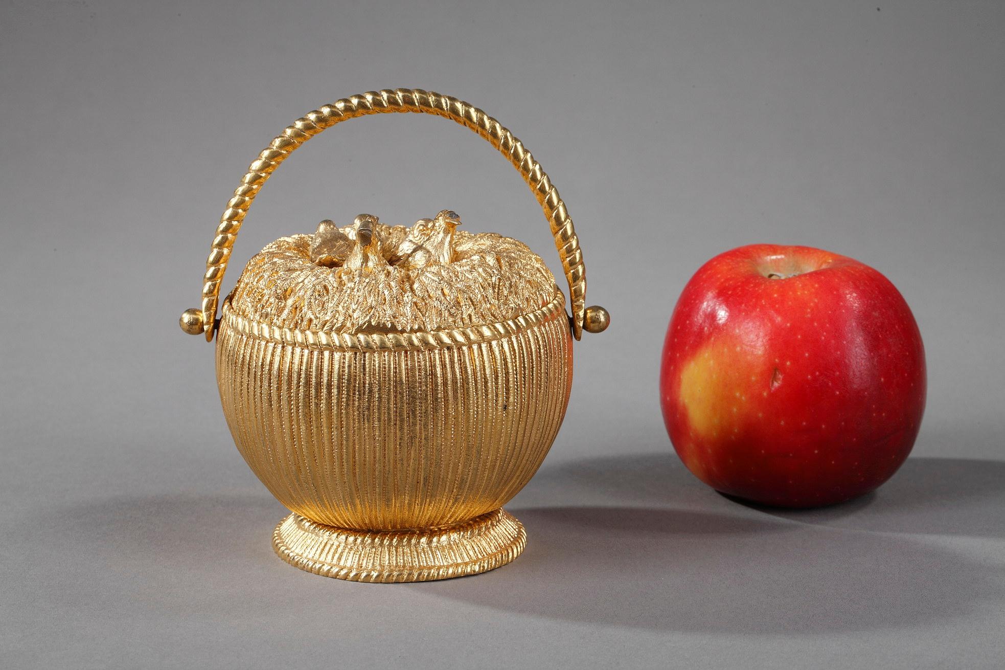 This small gilt bronze inkwell from the Restauration period takes the form of a wicker basket with a handle containing a nest. The lid represents a nest with five birds revealing two bronze cups and three feather holders.