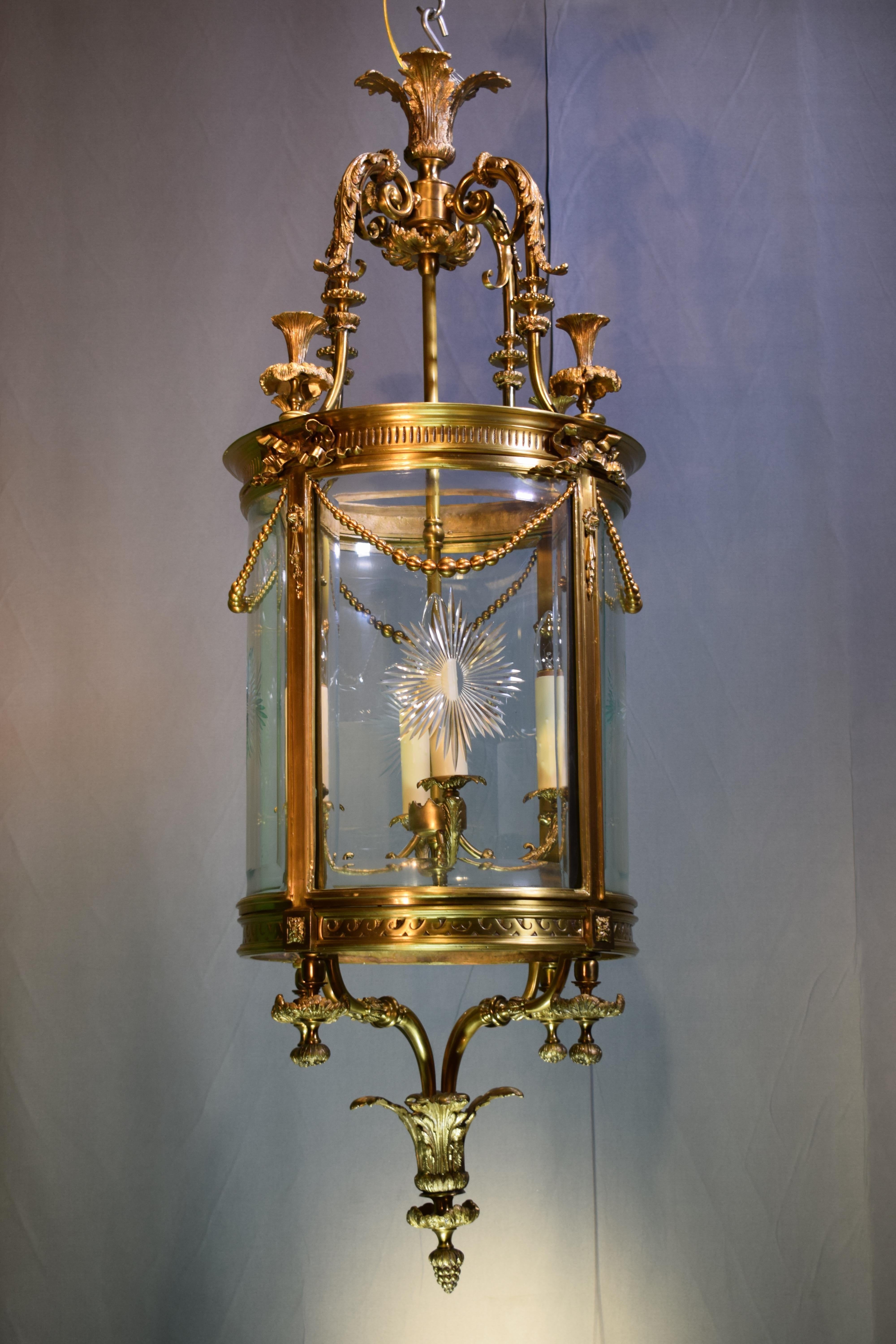A fine gilt bronze cylindrical lantern with hand-cut, curved and beveled crystal panels. England, circa 1920. 4 Lights
Dimensions: Height 54
