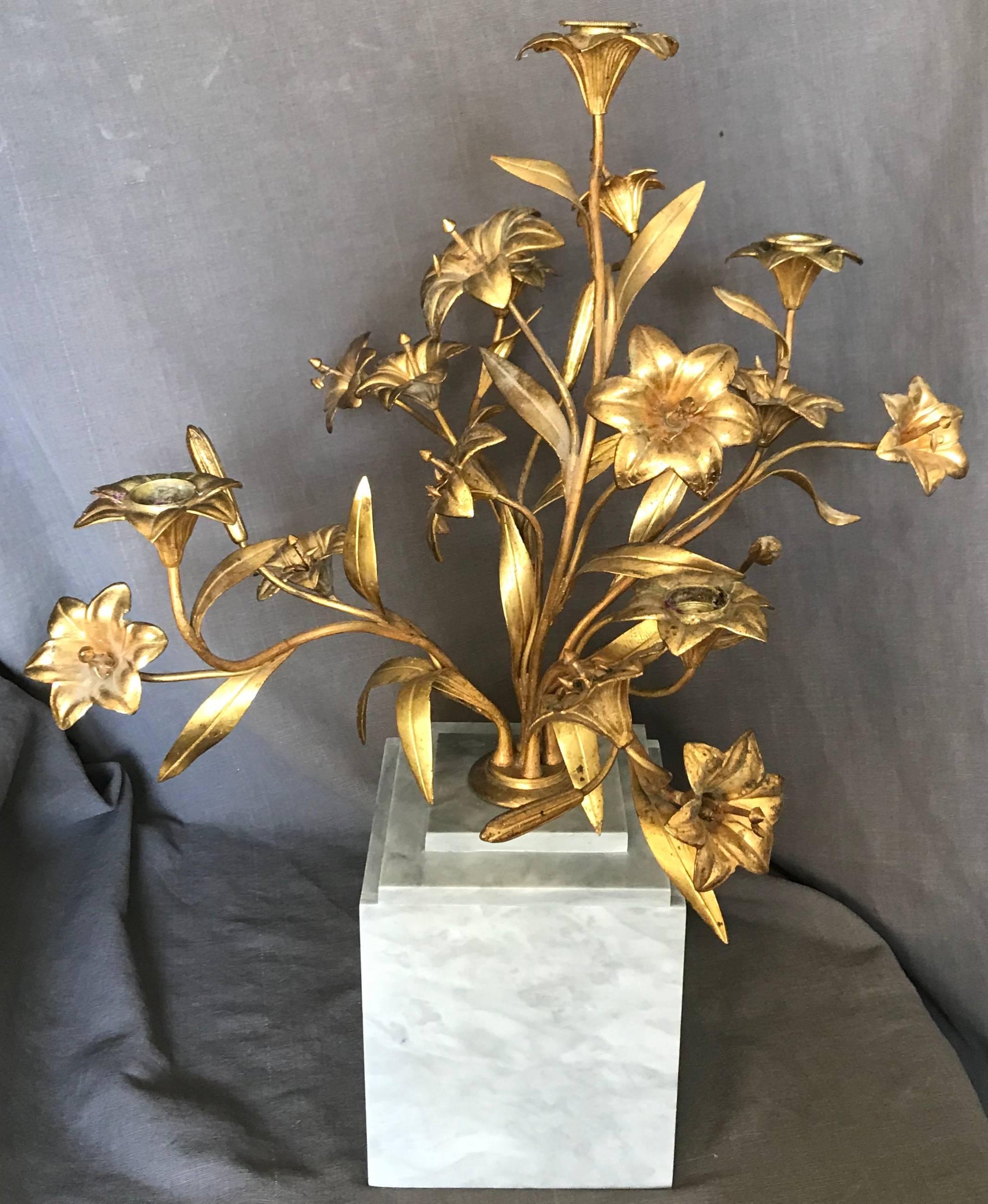 Gilt bronze lily candelabra. Gilt lilies candelabra sculptural centrepiece of five stems with lily buds and flowers terminating in five lily candelabra bases for candles all issuing from gilt base mounted on a modern grey marble plinth, France, 20th