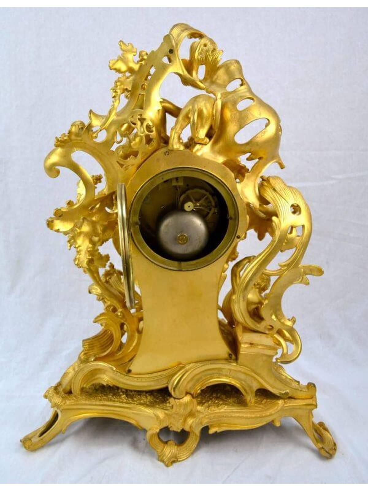 The case of this mantle clock is entirely of gilded bronze and represents the epitome of the Rococo revivalist style in mid-late 19th century France. Leafy scrolls entwine the entire case, the dial comprises inset white enamel plaques with blue