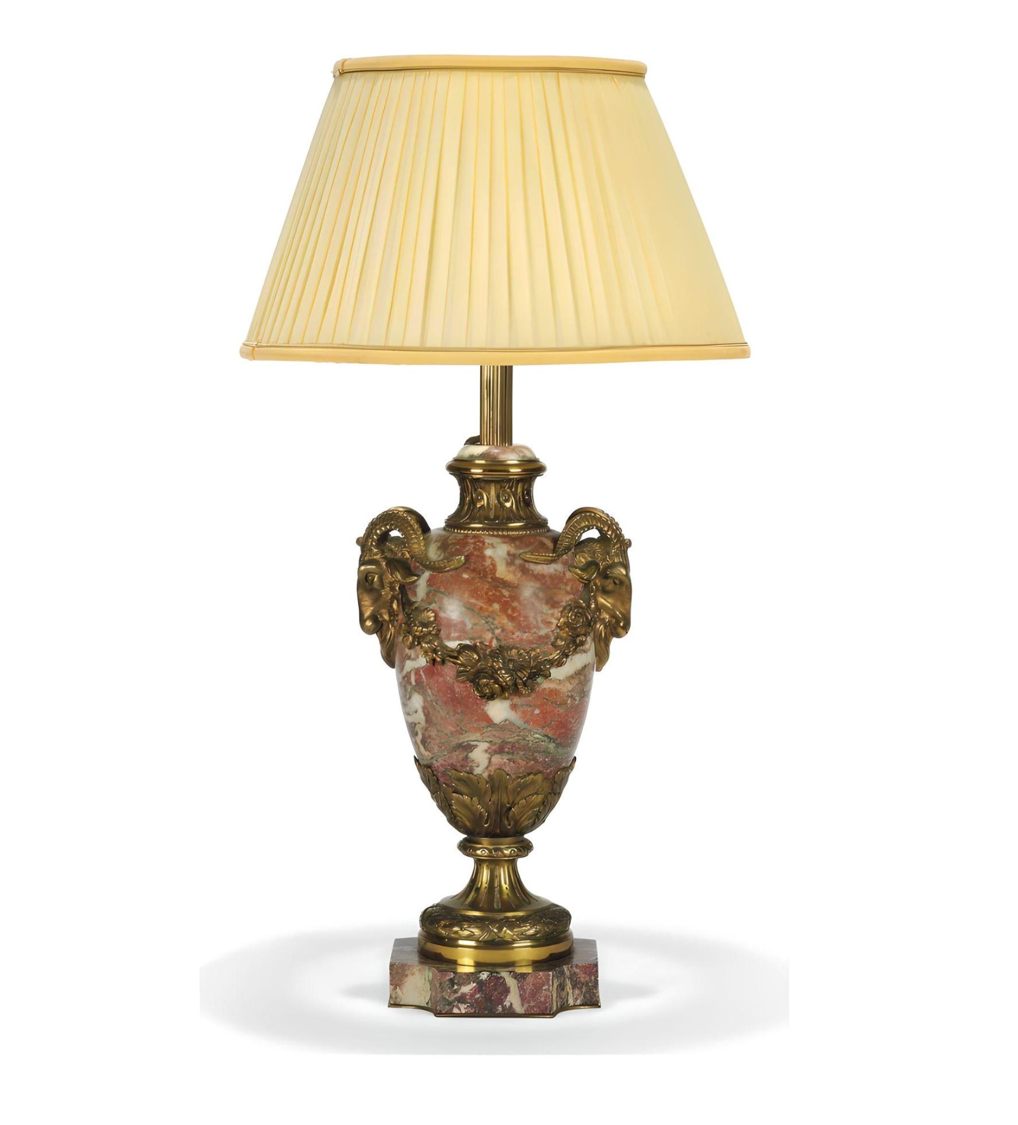 Lampe de table en marbre monté sur doré, début du 20e siècle. Extrêmement bien fabriqué avec les meilleurs matériaux.

Le corps de l'urne avec deux poignées en forme de masque de bélier sur une base carrée avec des coins rentrants, équipée pour