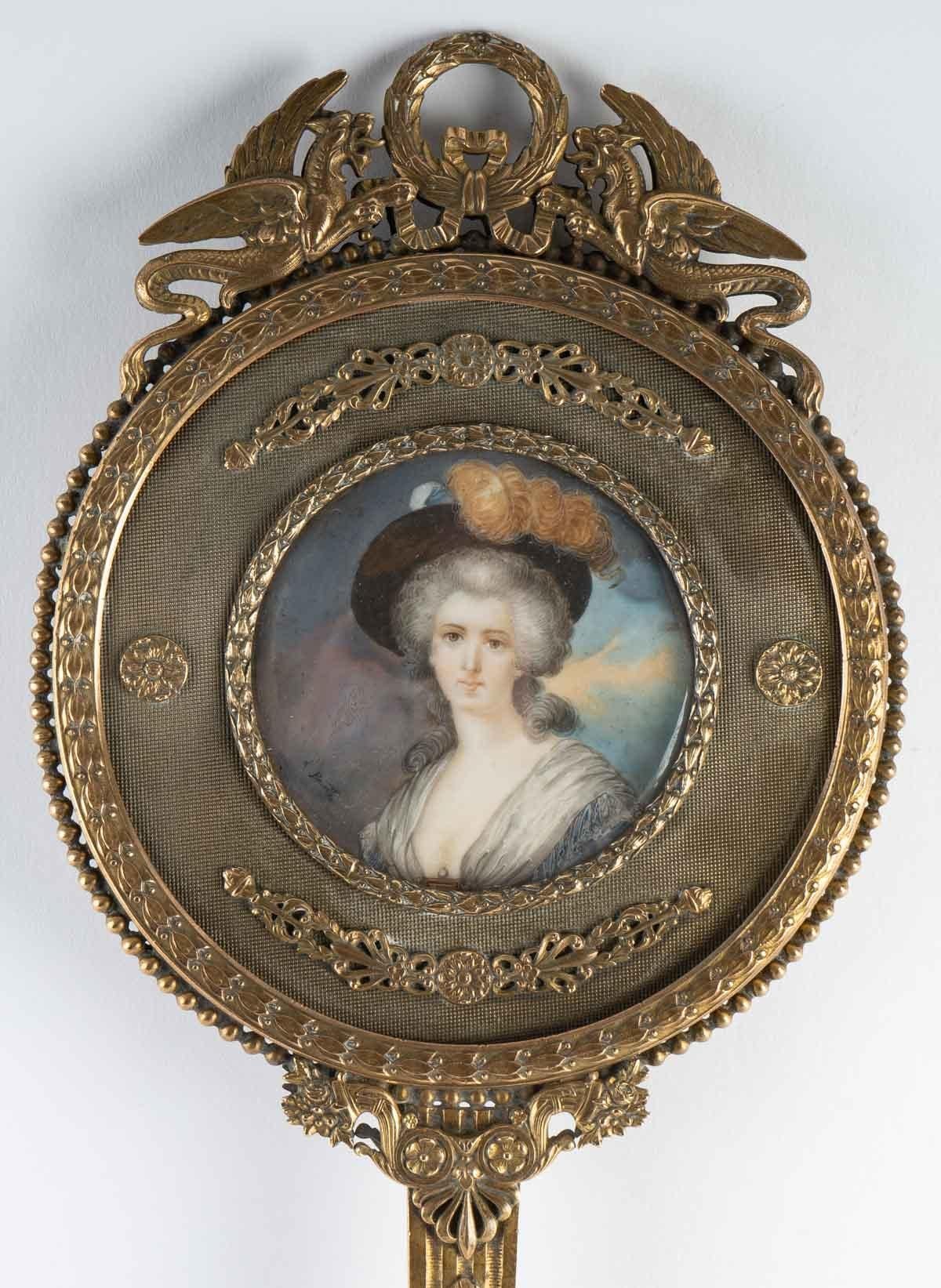 Superb gilt bronze mirror, 19th century, richly carved. It contains a miniature representing a lady of the court.

Parisian work from the end of the 19th century.
Measures: Diameter 34 cm, height 14 cm.