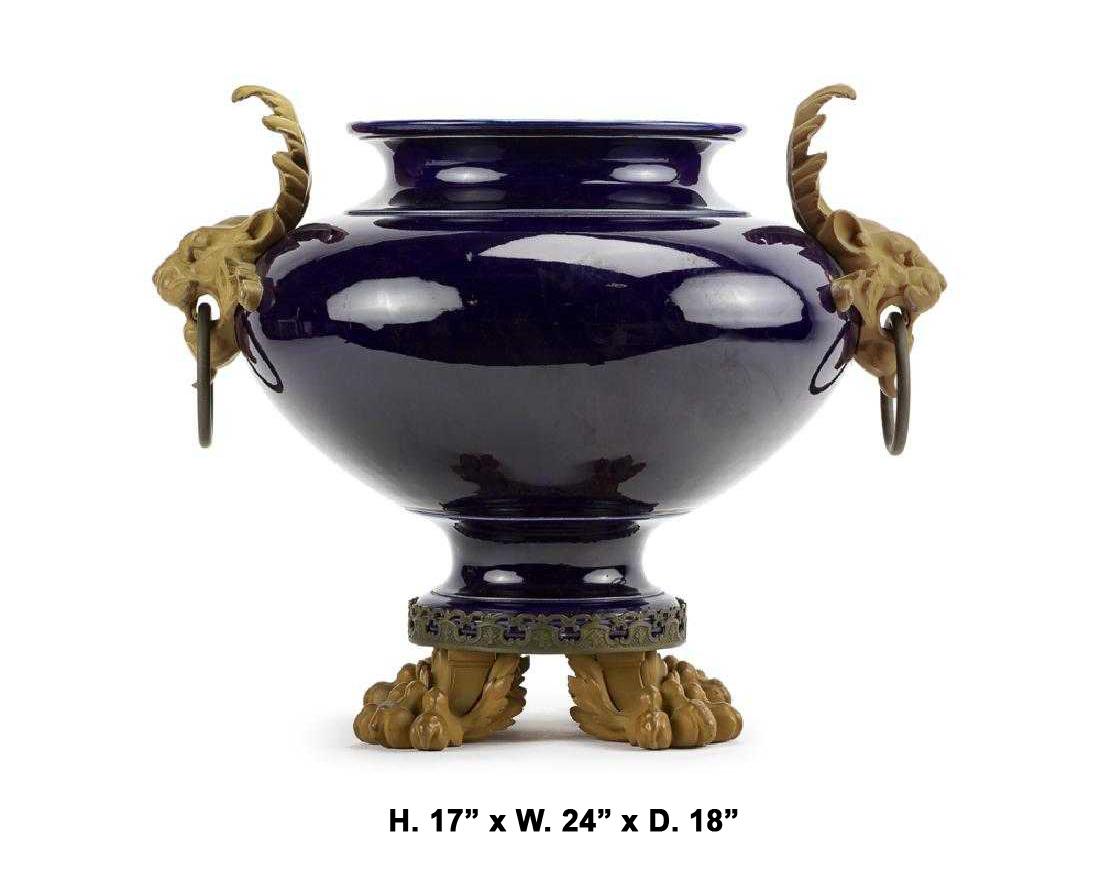 Impressive Italian gilt bronze mounted cobalt blue porcelain jardinière centerpiece, circa 1900.

The large and exaggerated ovoid cobalt blue porcelain body is flanked by two beautiful lion's heads with handles, supported by gilt bronze lion feet.