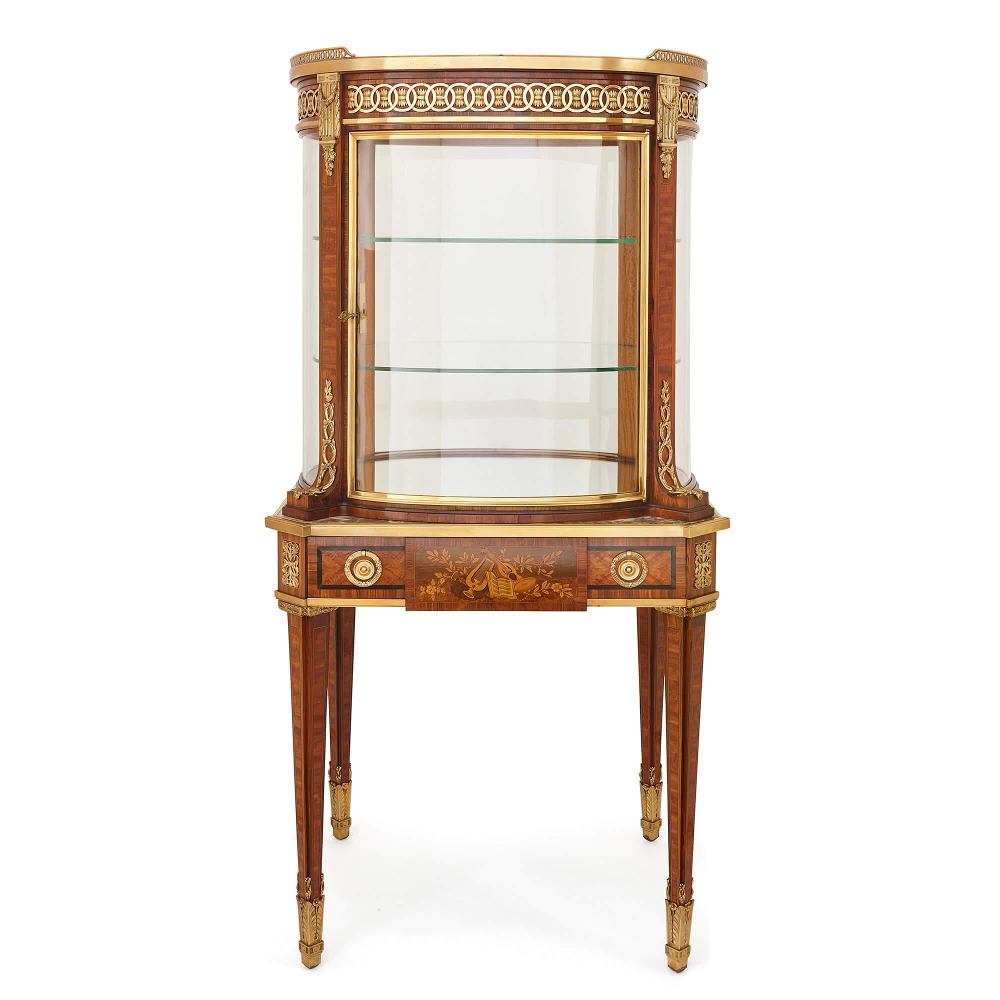 This stunning display cabinet-on-table is not a piece to hide in a corner of a room, but one to place firmly in the centre, thanks to its sophisticated, elegantly-curved design with glass on all sides of the piece, allowing it and its contents to be